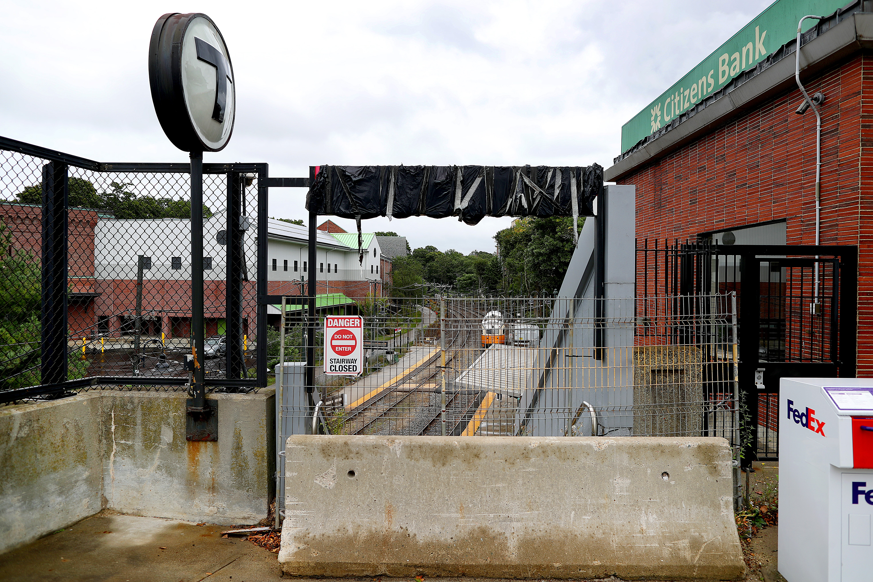 A Jersey barrier blocks the crumbling concrete staircase at the Milton Station on Adams Street.