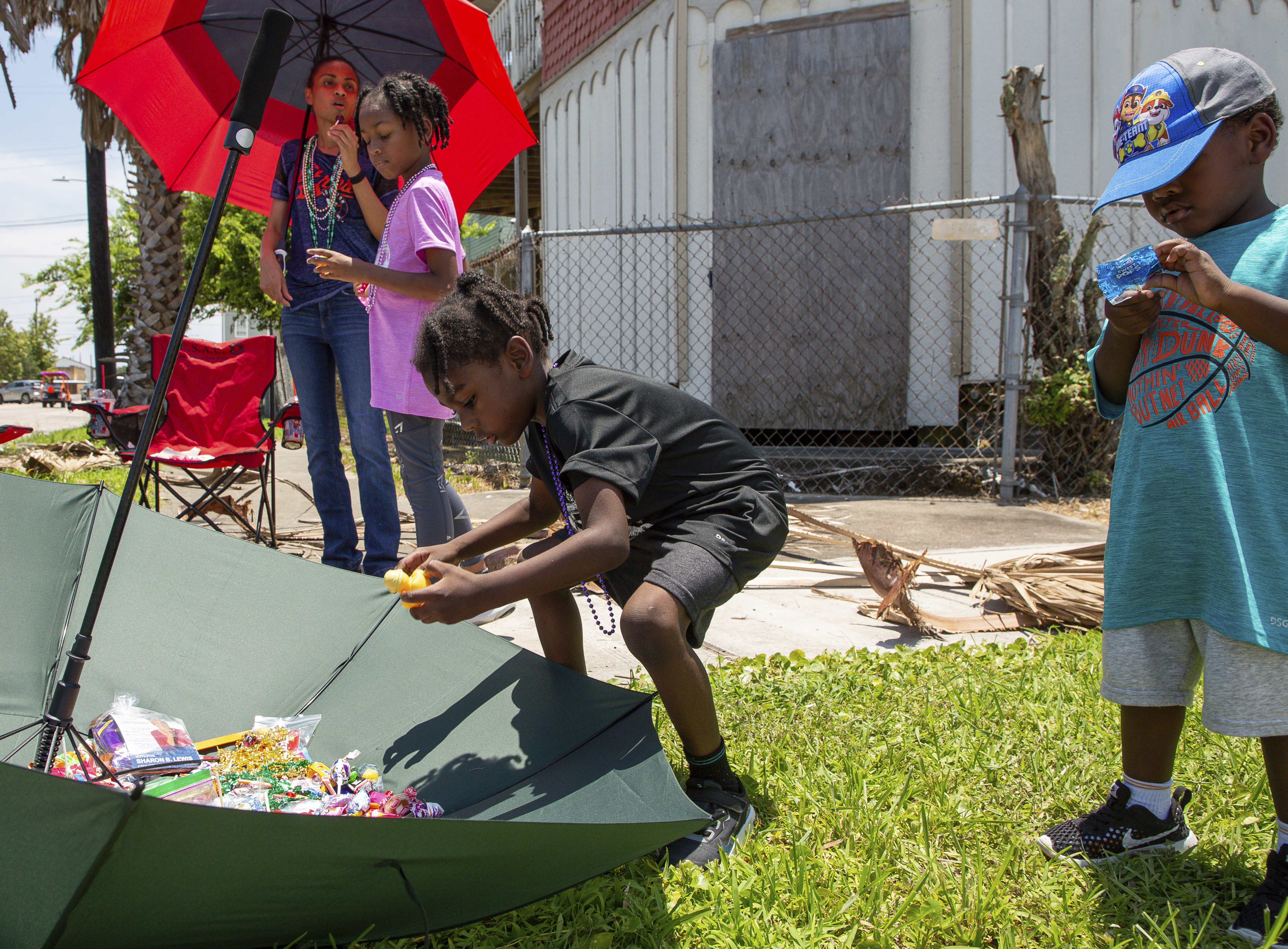 Xavier Stevens, center, puts candy collected during the Juneteenth Parade inside an upside down umbrella on Saturday, in Galveston, Texas.