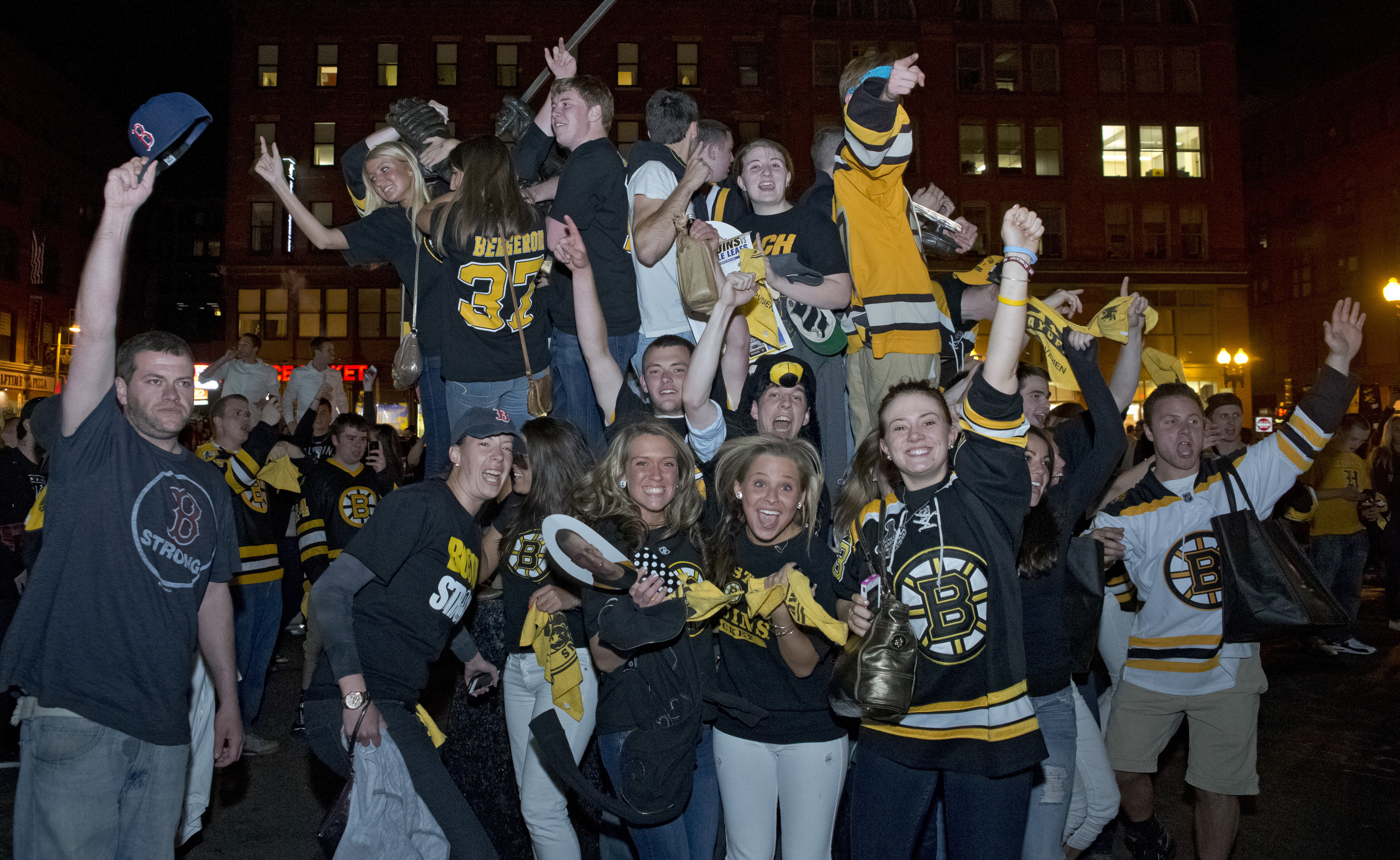 Bruins fans celebrate their 5-4 sudden death victory over the Toronto Maple Leafs in the playoffs as they hang off of the Bobby Orr statue in 2013.
