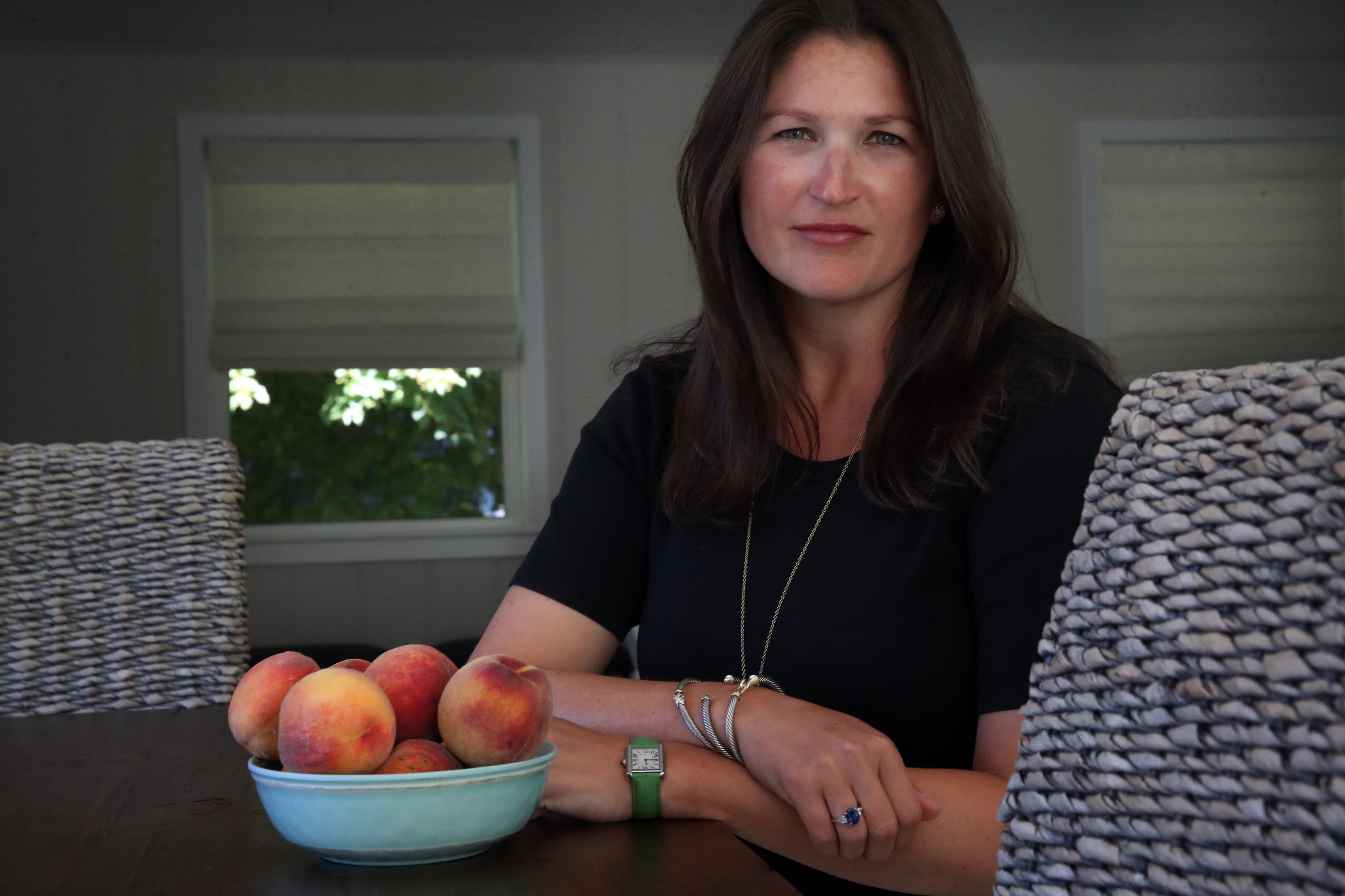 Laura Ogonowski posed with a bowl of peaches from White Gate Farm, at her home in Orleans.