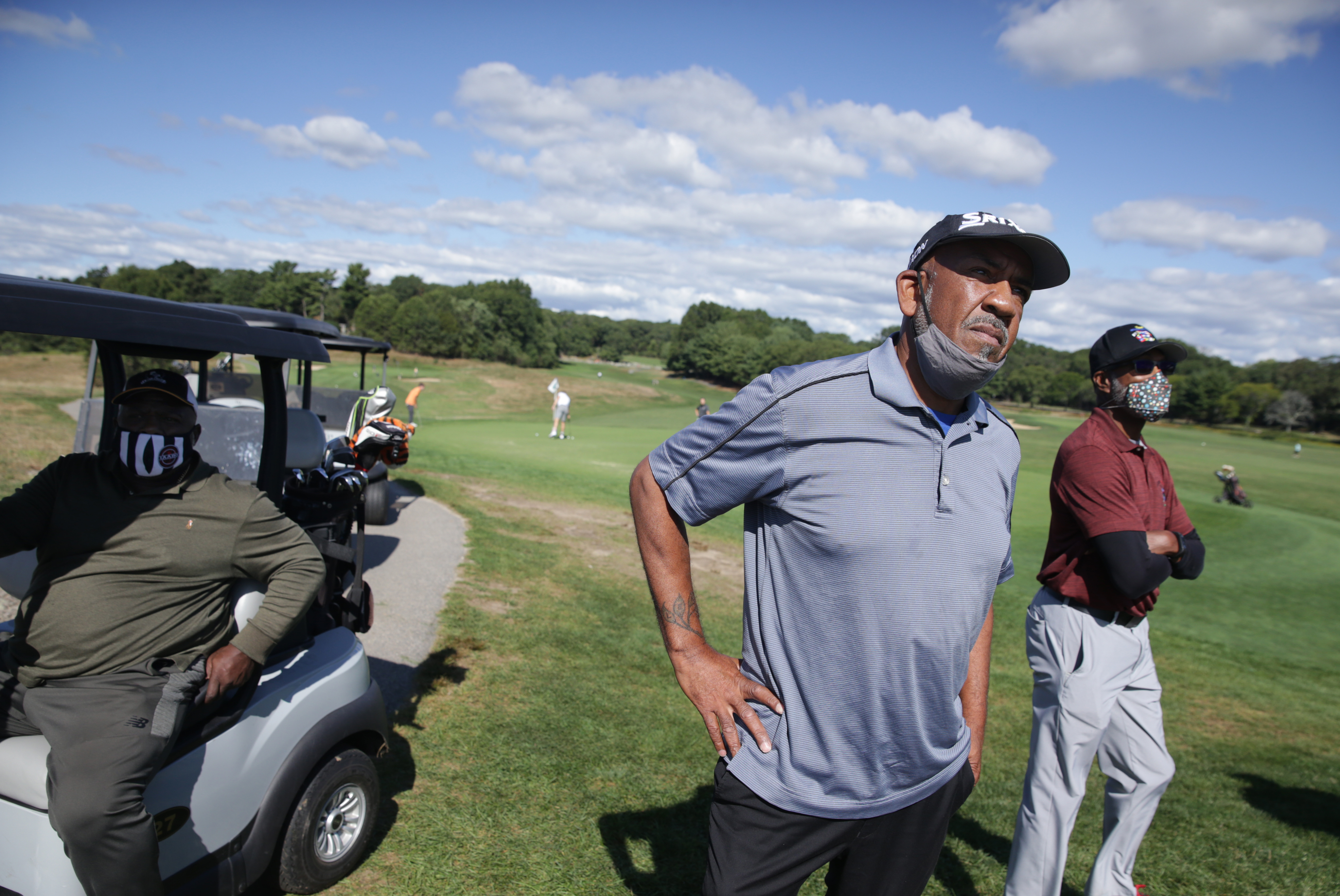 Kenny Lightfoot waited in a cart as Charlie Harris and William Lodge watched a friend tee off at the William J. Devine Golf Course at Franklin Park.