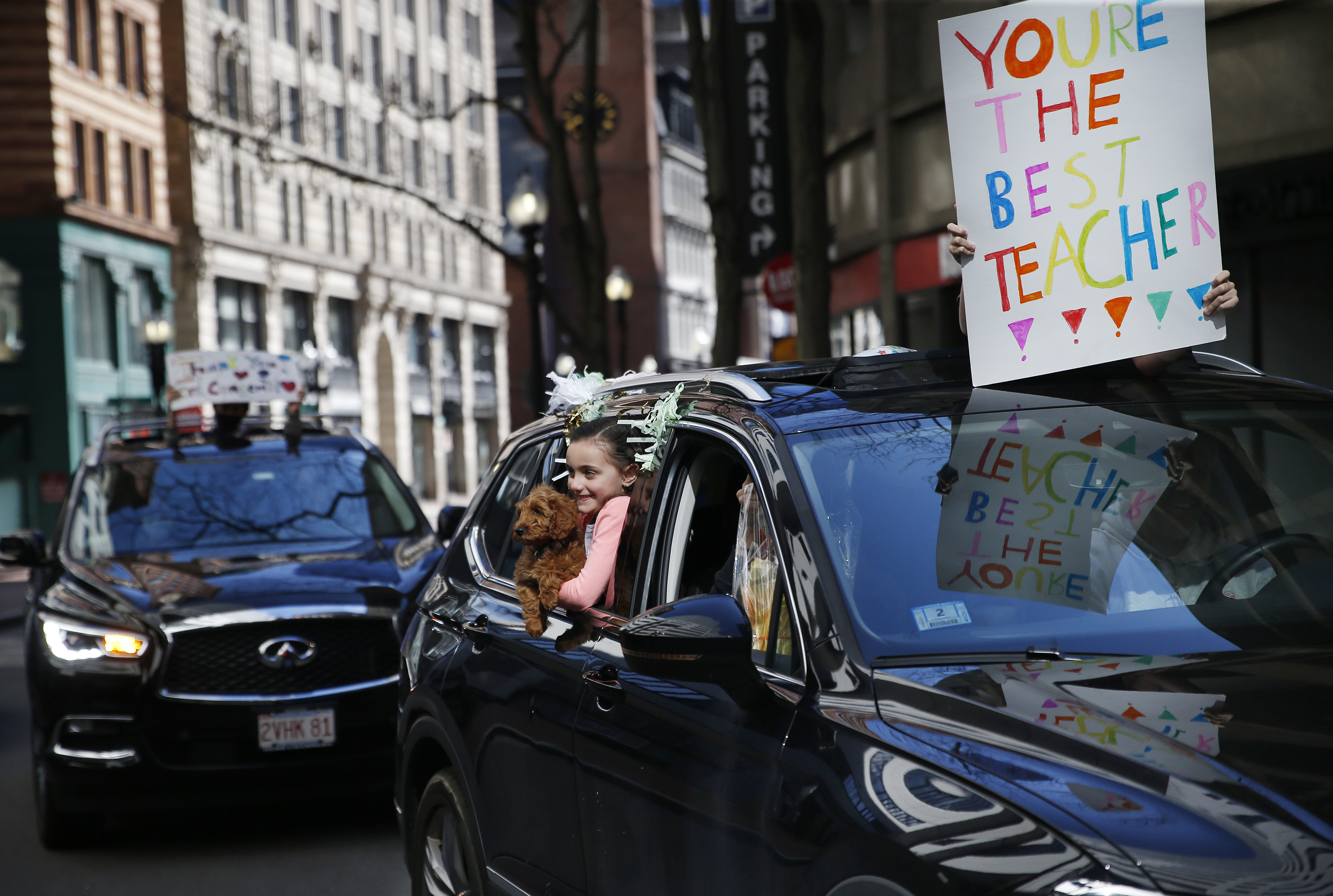 Boston, MA - 5/5/20: St. John School student Karis Hennessey, 6, holds onto her puppy Cooper during a surprise parade for Megan Congemi on 