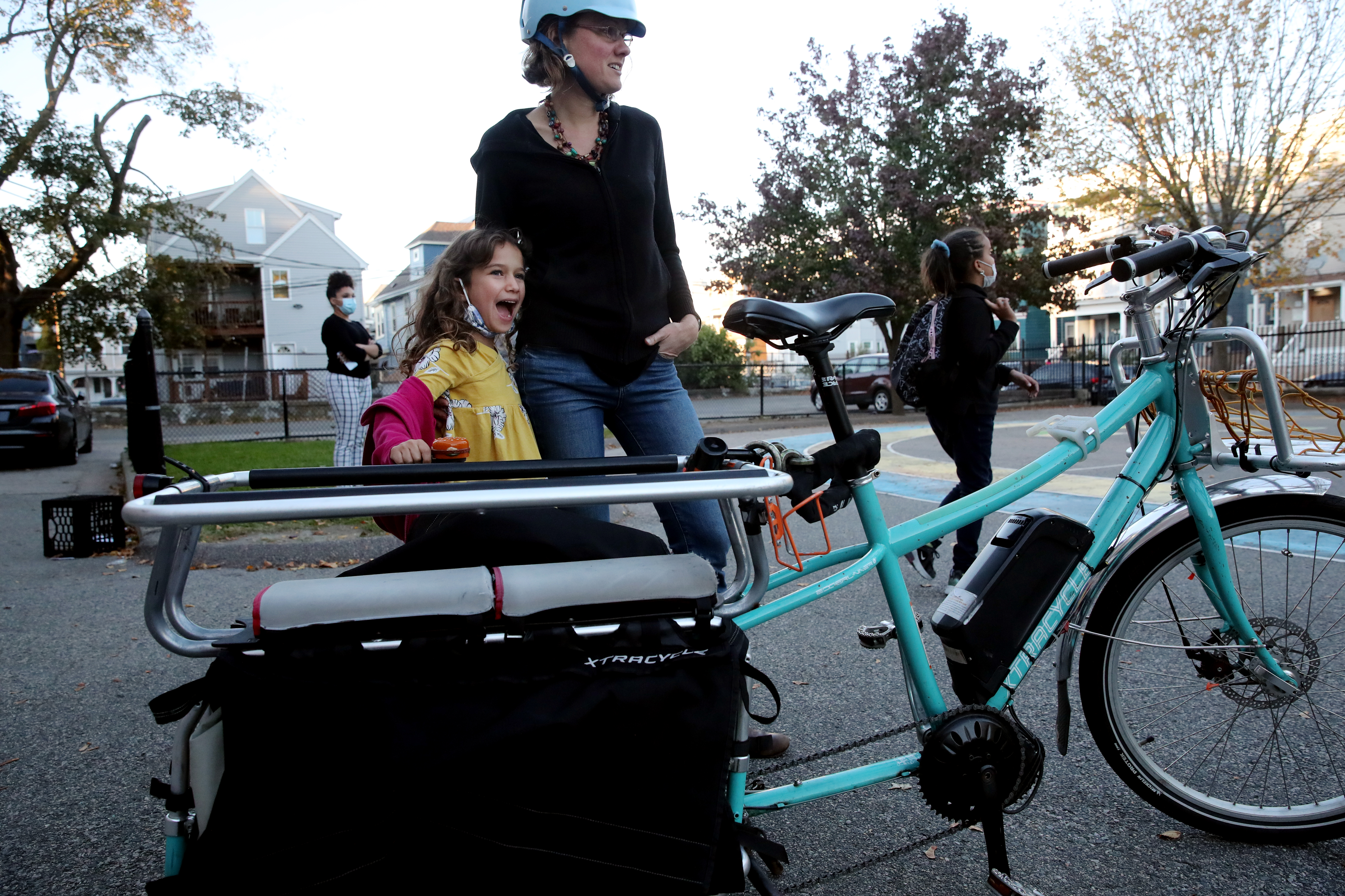 Jana Pickard-Richardson waited with her daughter Clió while picking up her children on her cargo bike at Sarah Greenwood School in Boston on Tuesday.