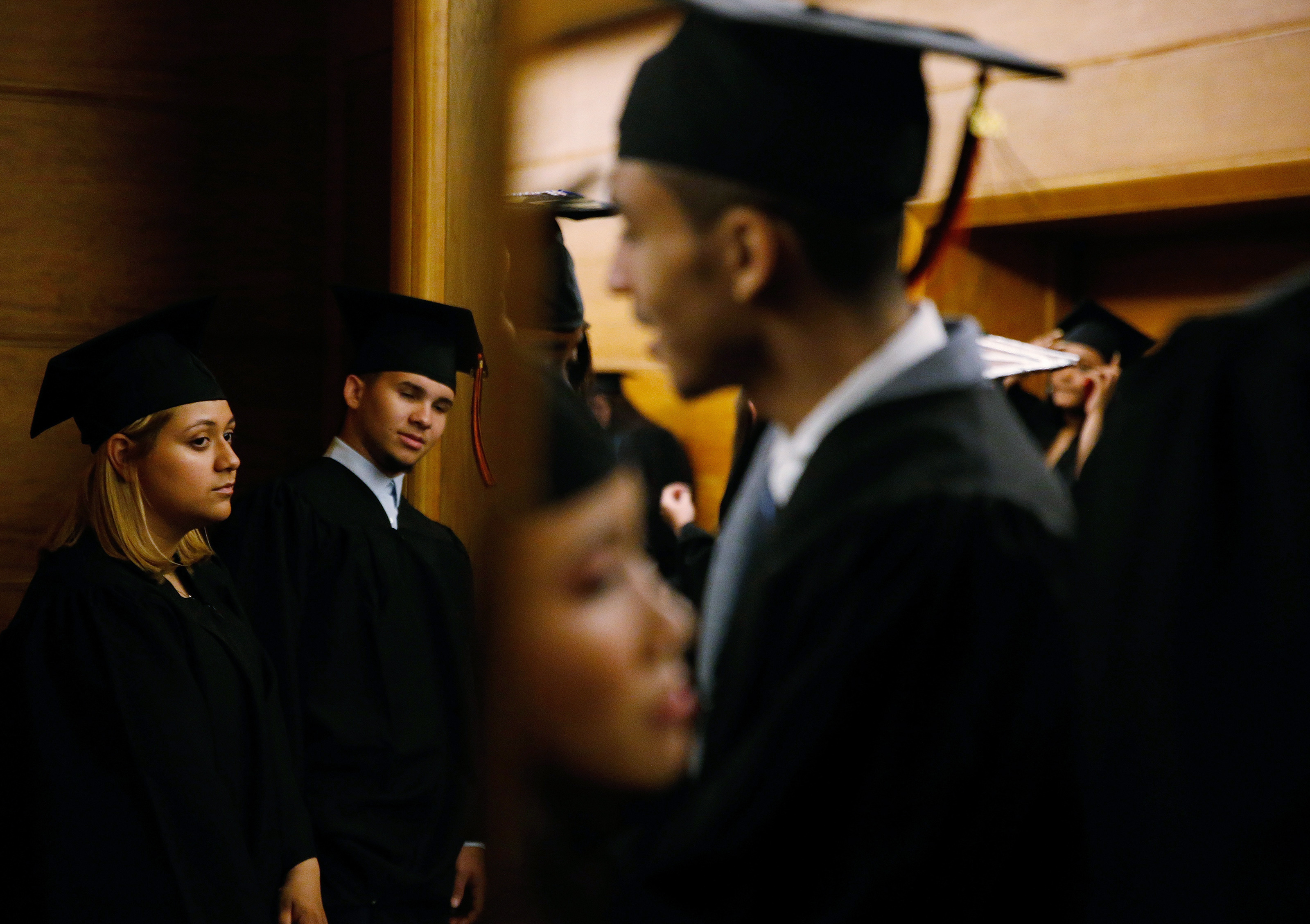 Britney Mendez (left) waited in line with other graduates during Brighton High School’s graduation, the final step in her journey through the Boston Public Schools.