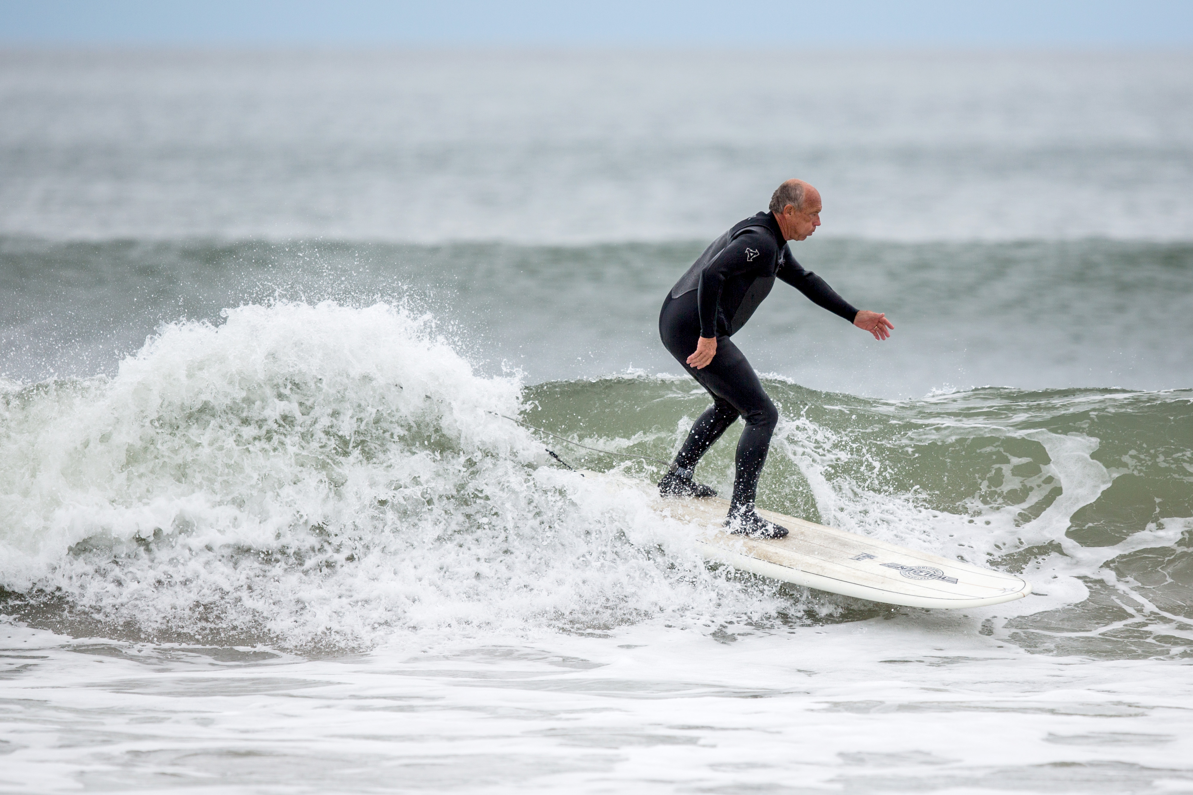A surfer at Hampton Beach. Summer Sessions in Rye and Cinnamon Rainbows in Hampton have boards for rent and sale, wetsuits, and everything you need to get started, including lessons and surf camps geared to kids or senior citizens.