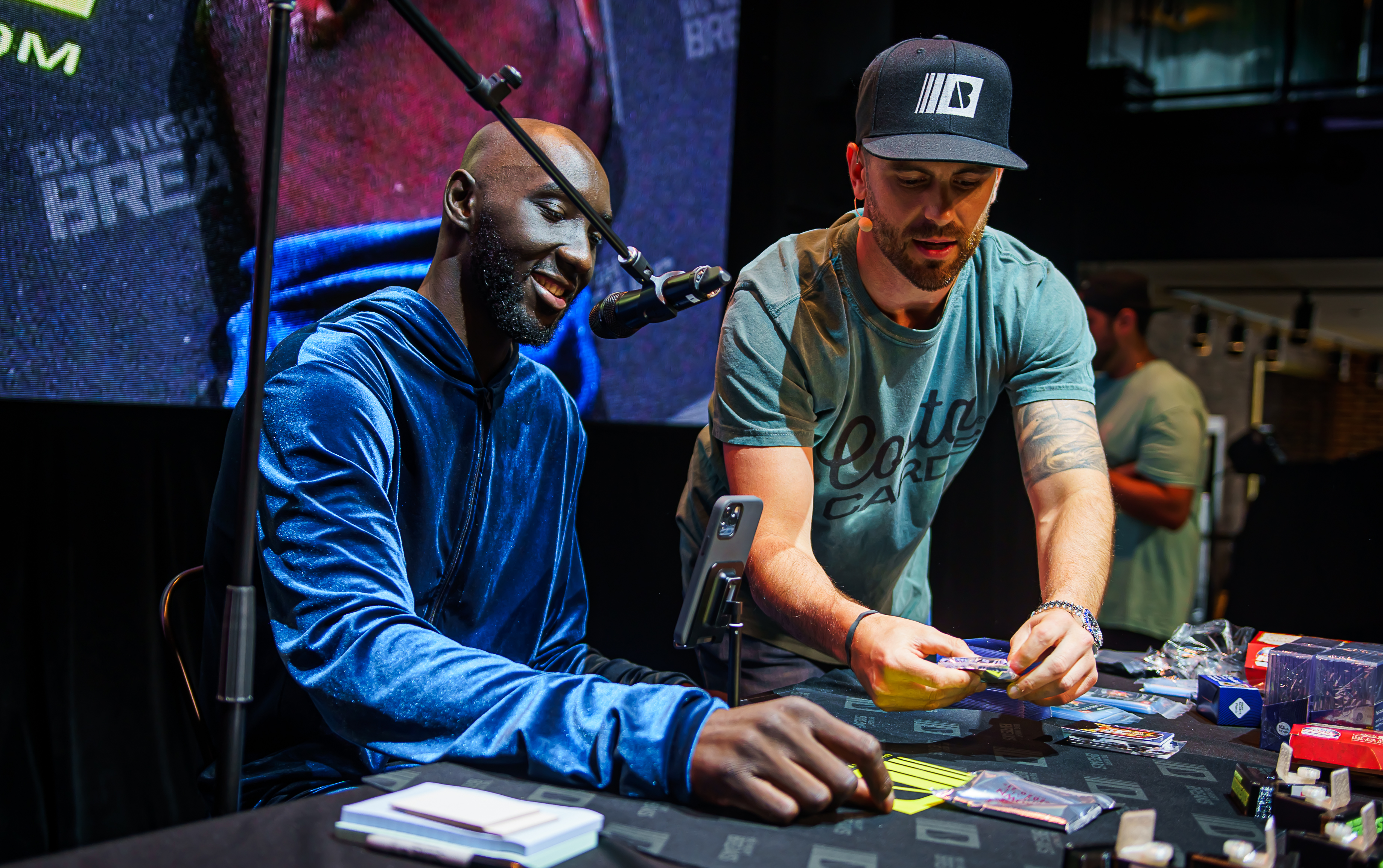 Celtics fan favorite Tacko Fall "ripped" packs at the Causeway Card Show with Chris Costa, one of the organizers.