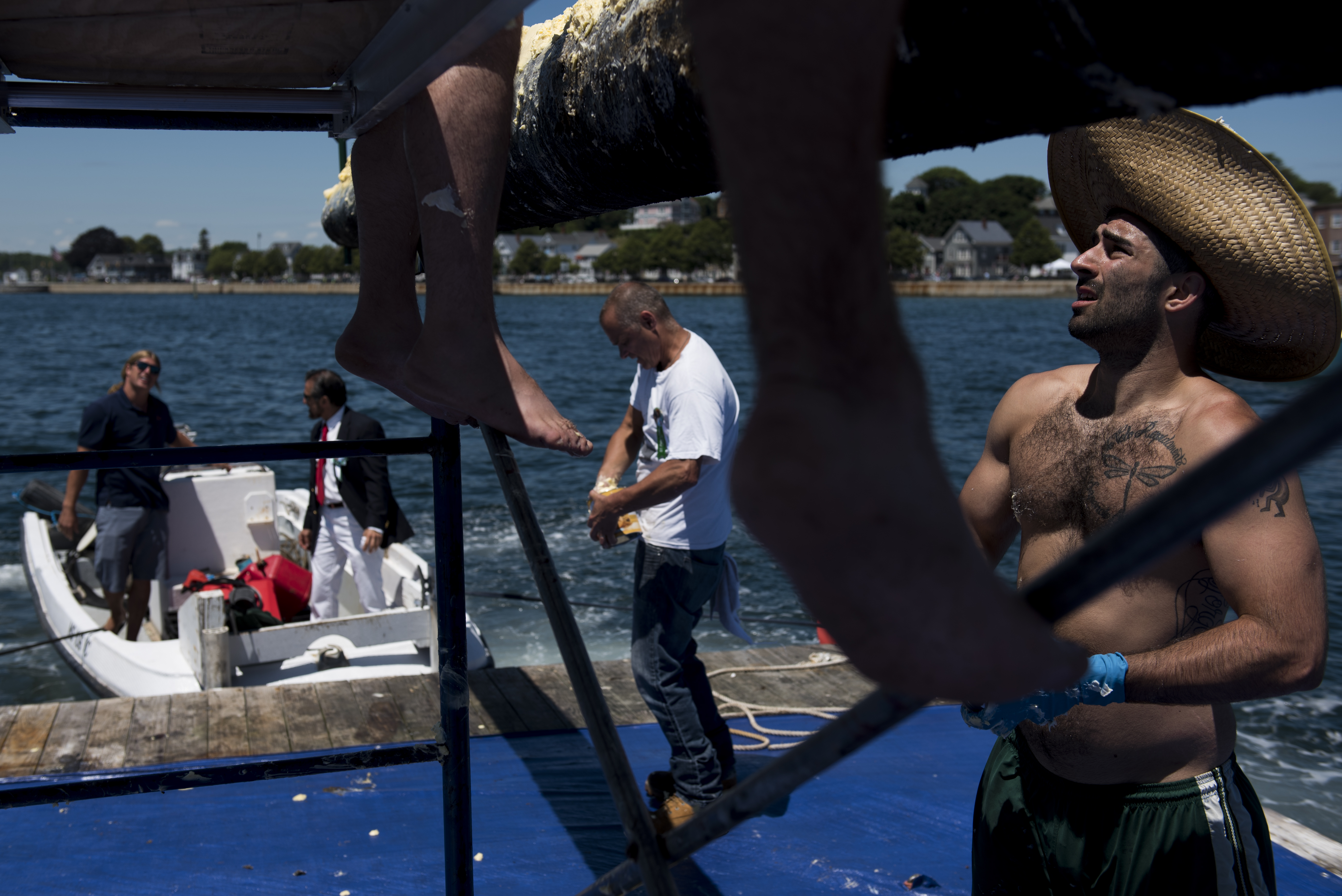 Mike Forgetta, 26, of Gloucester, applies crisco to the greasy pole with the rest of the "Grease Crew."
