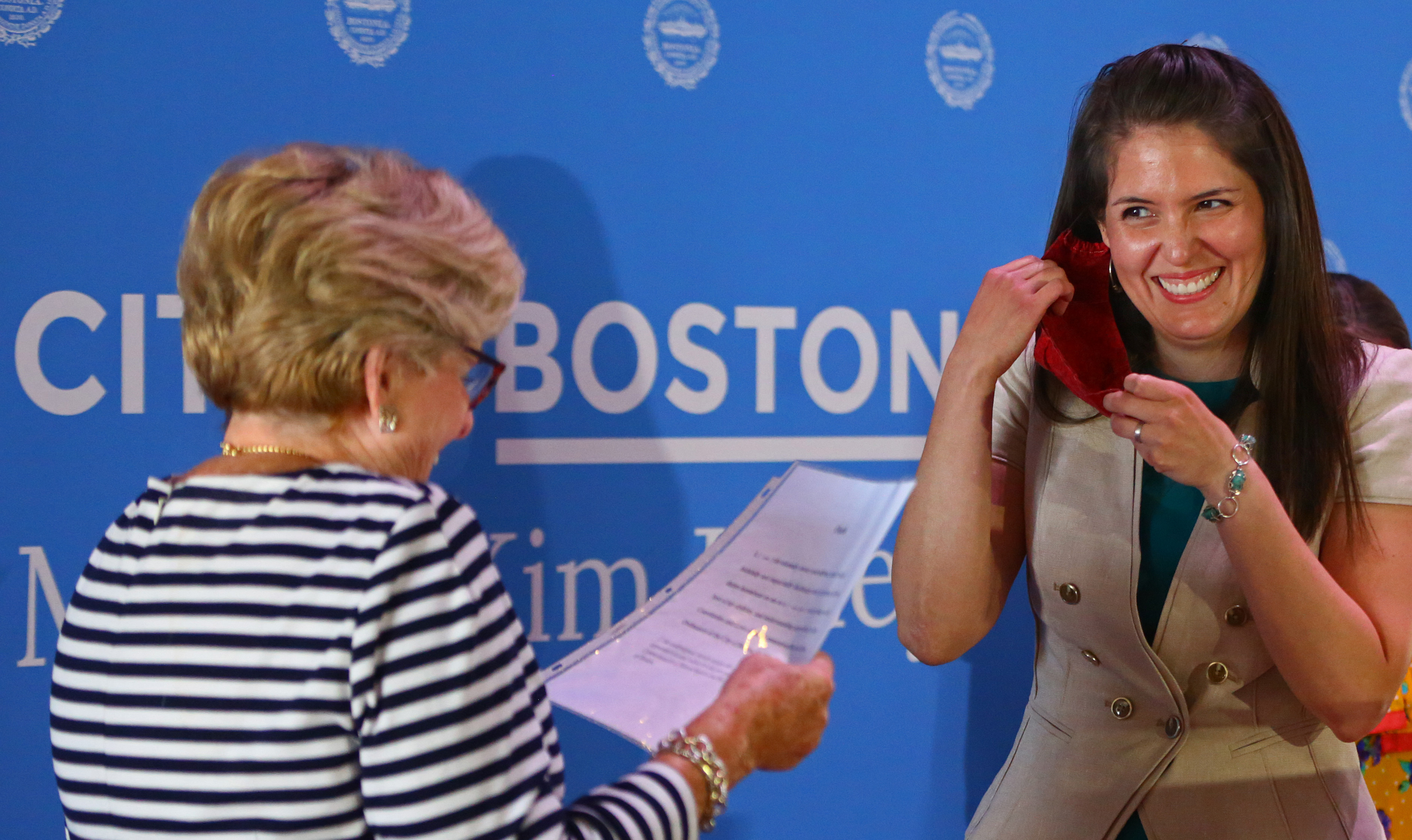 Lorena Lopera removed her mask before being sworn in by City Clerk Maureen Feeney as one of two new Boston School Committee members.
