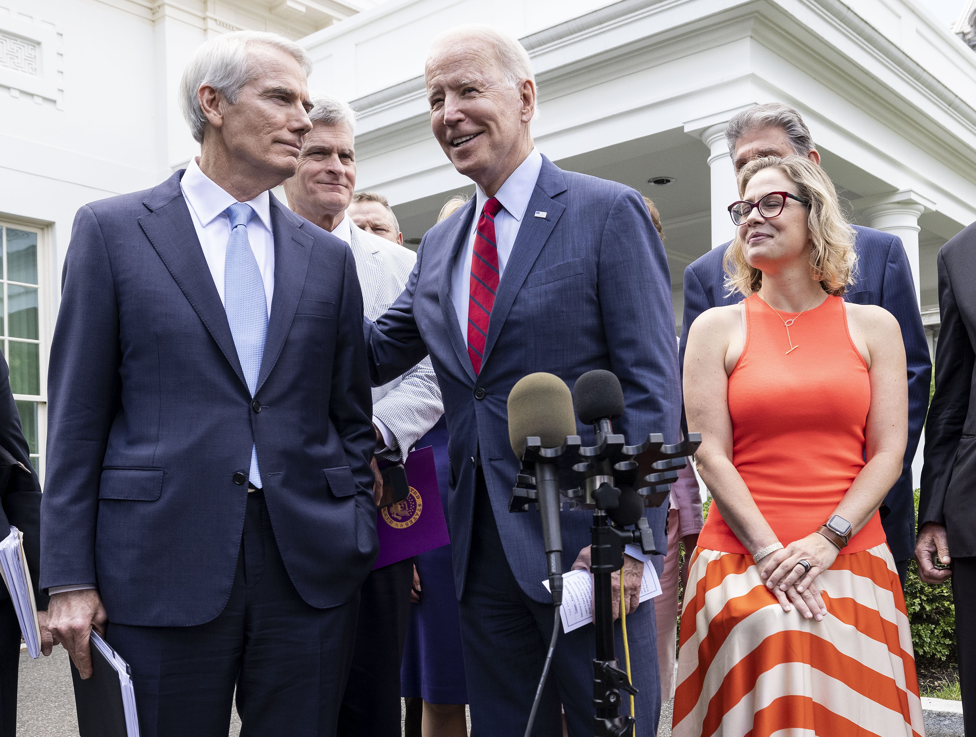 President Joe Biden puts his arm on Republican Senator Rob Portman.