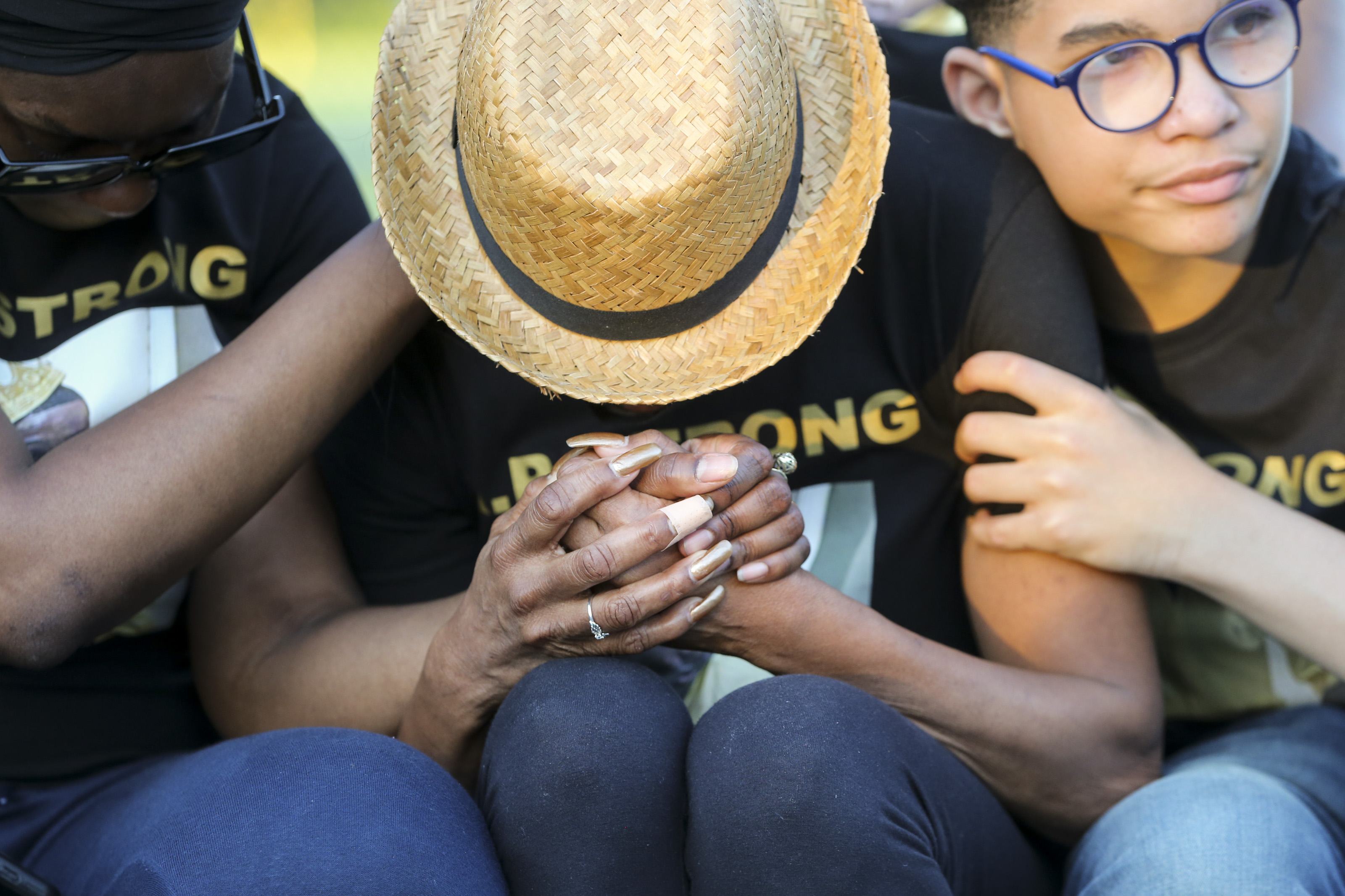 Debra Rowell (center) is comforted during the vigil for her son Alonzo Polk.