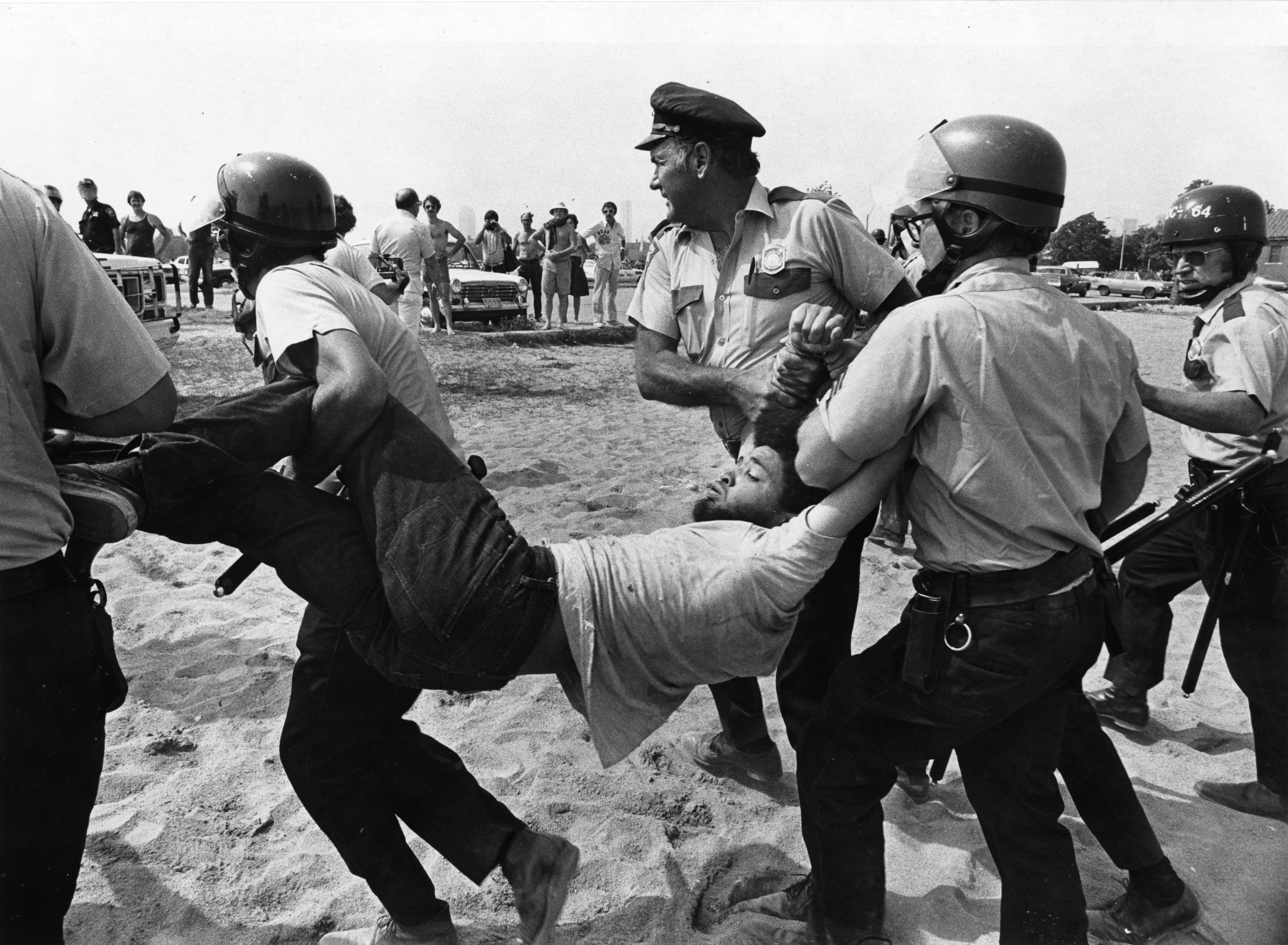 A man was carried by Boston police on Carson Beach in South Boston on Aug. 10, 1975. Hundreds of officers were called in when Black demonstrators asserting their right to use the beach were met by throngs of white counterprotesters. Forty people were injured.