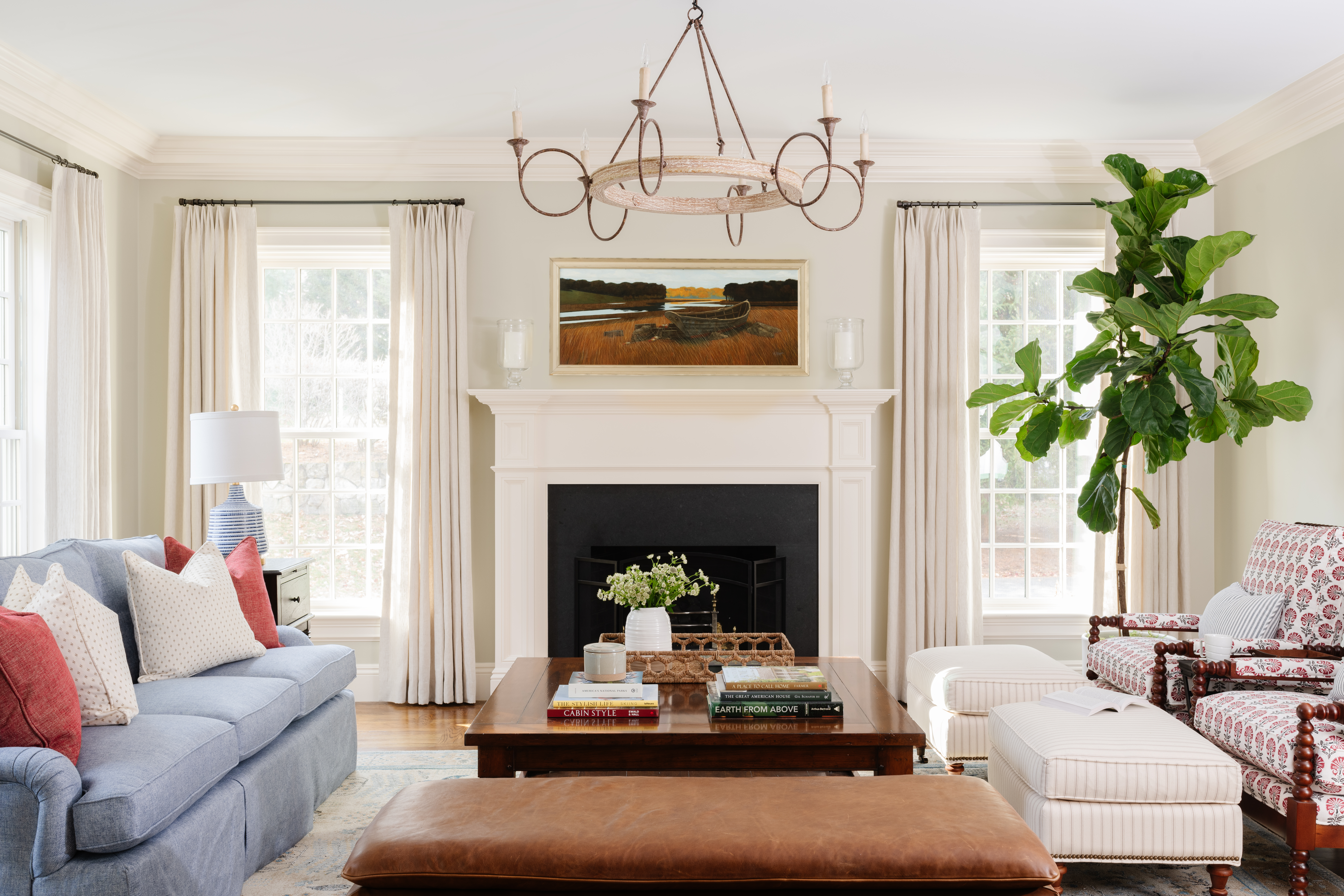 The burnished tones of the table, bench, and rusted metal chandelier tie to the autumnal landscape by Steve Rogers.