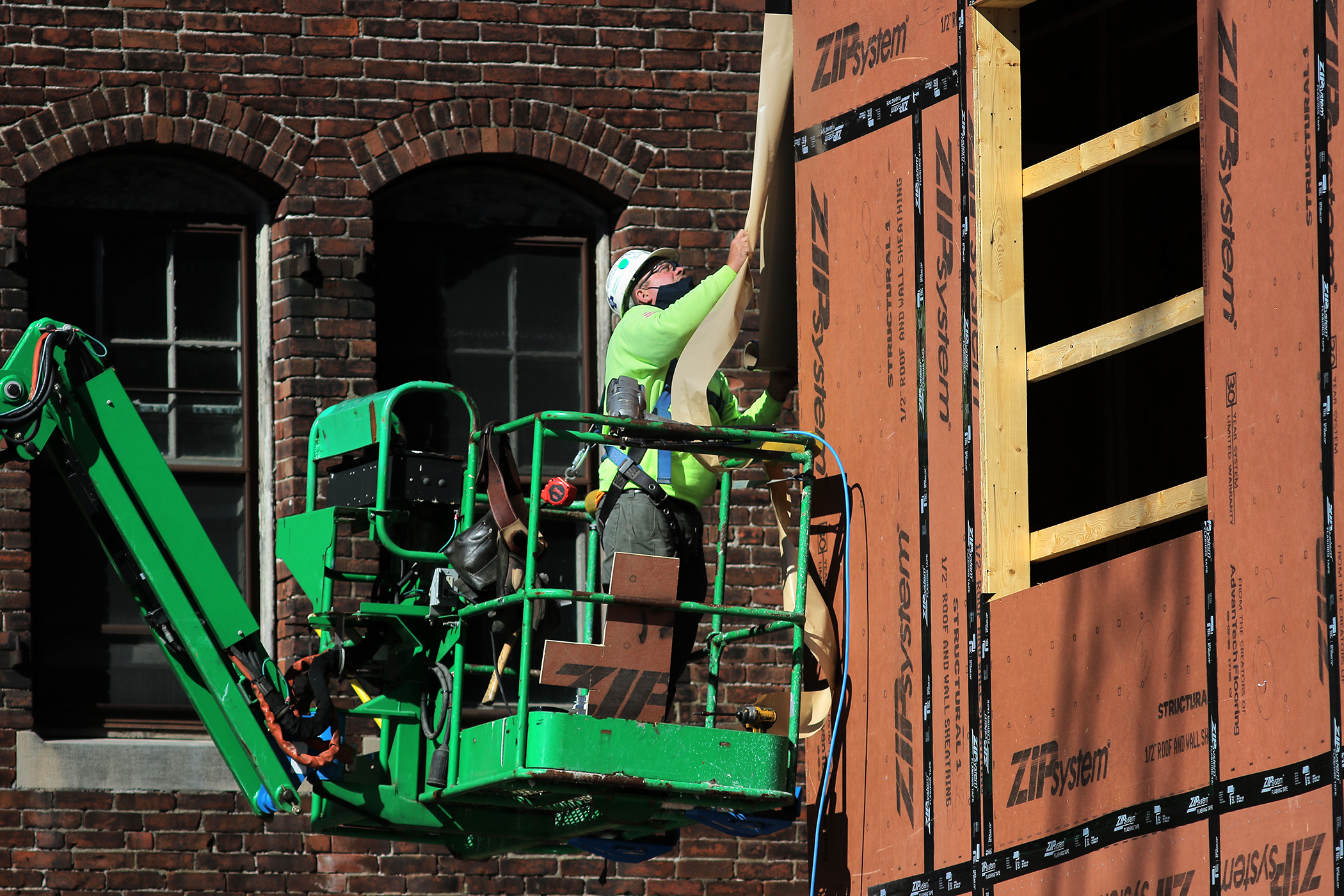 A laborer works on the new apartment building at 121 Main Street in Brockton.