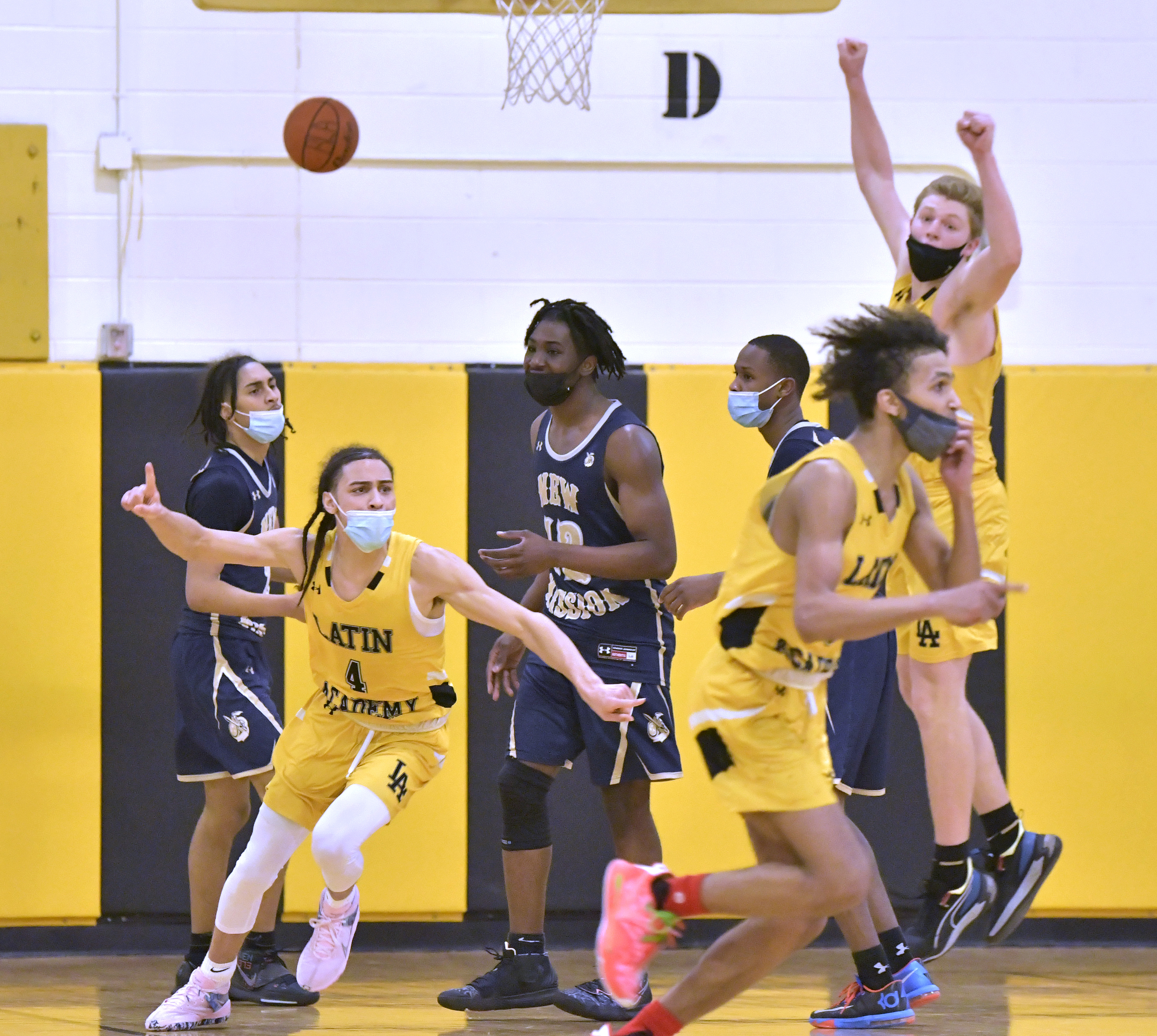 Latin Academy's Benny Martinez (4), Tianu Santos (3) and Brennan Shapiro (23) react at the buzzer as they finished off a win over New Mission for the program's first Boston City League championship since 1993.