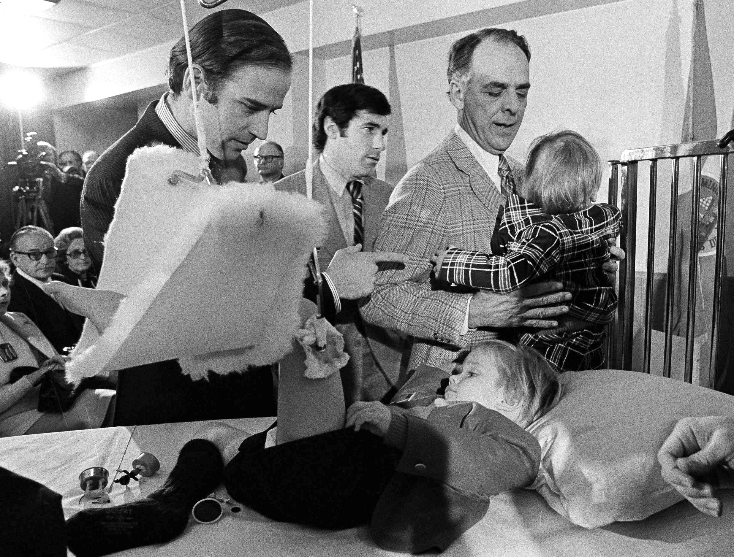 Joe Biden (left) offered words of encouragement to his bedridden son, Beau, before Joe Biden was sworn in as a senator in January 1973. Biden's other son, Hunter, talked with Robert Hunter, Biden's father-in-law. Beau was still in traction from the auto accident that killed his mother and his sister.