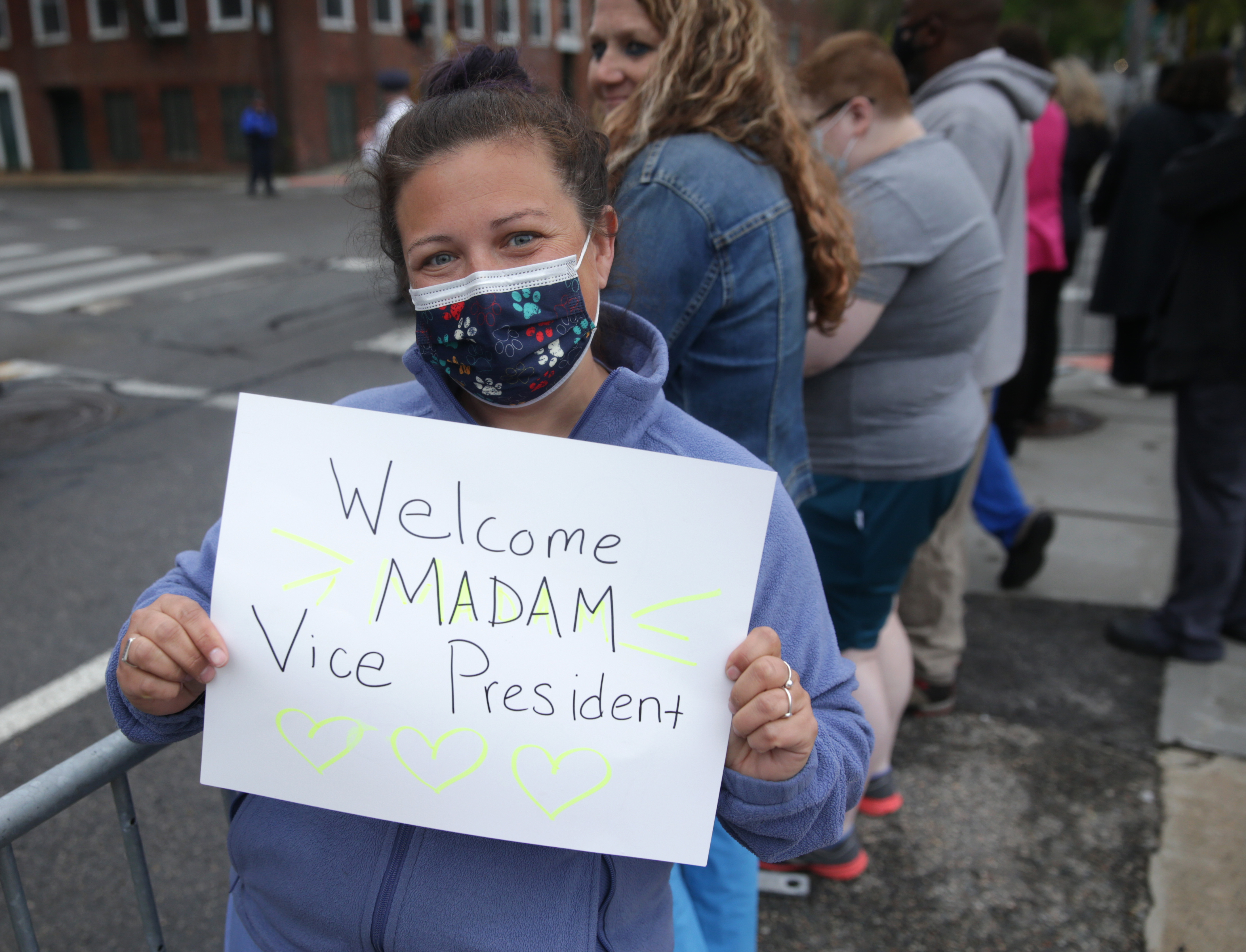 Michelle Sylvester holds a sign welcoming Vice President Kamala Harris to Providence.