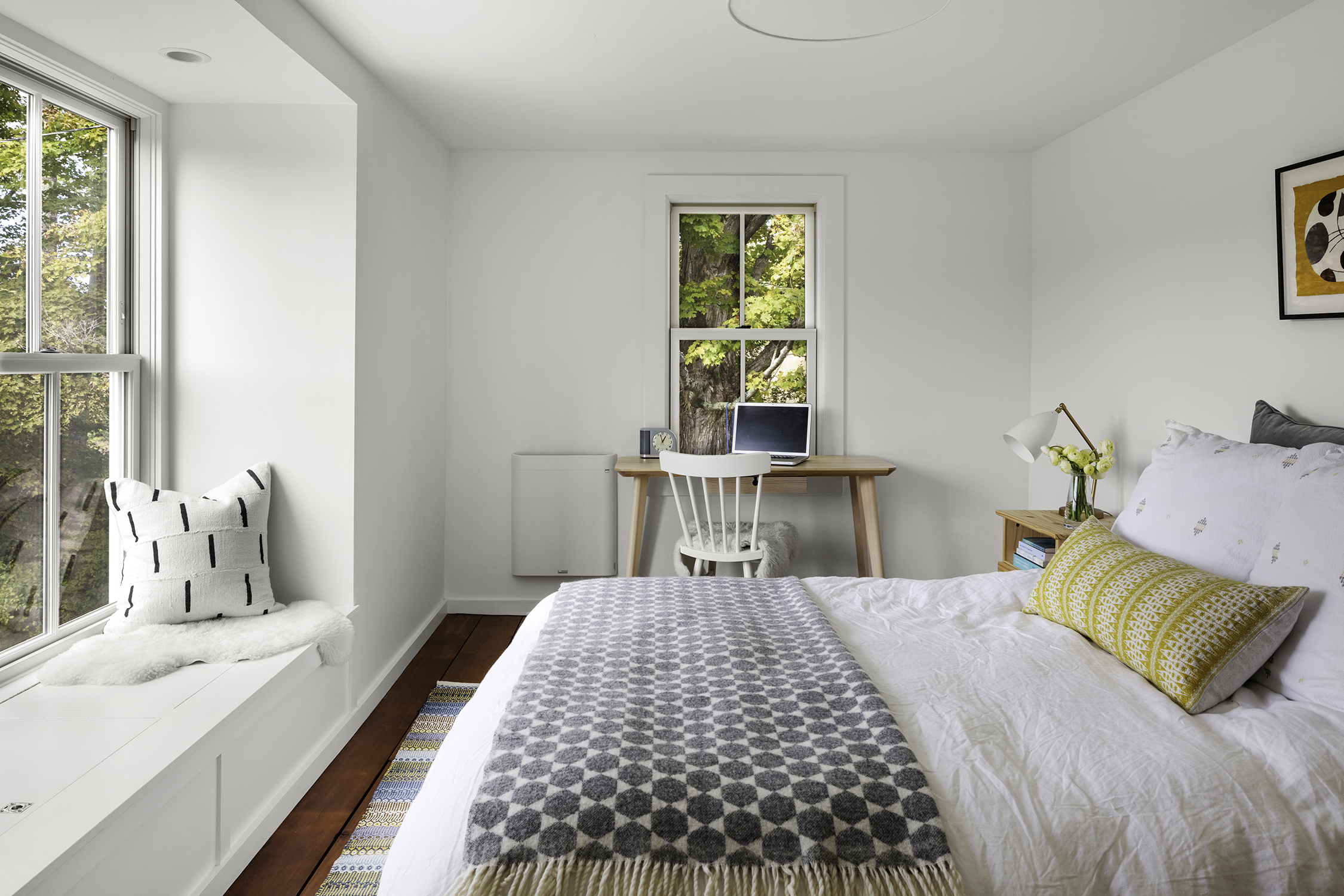 The bay in the couple’s bedroom provides hidden storage for blankets. The throw pillows are from Hammertown in Great Barrington.
