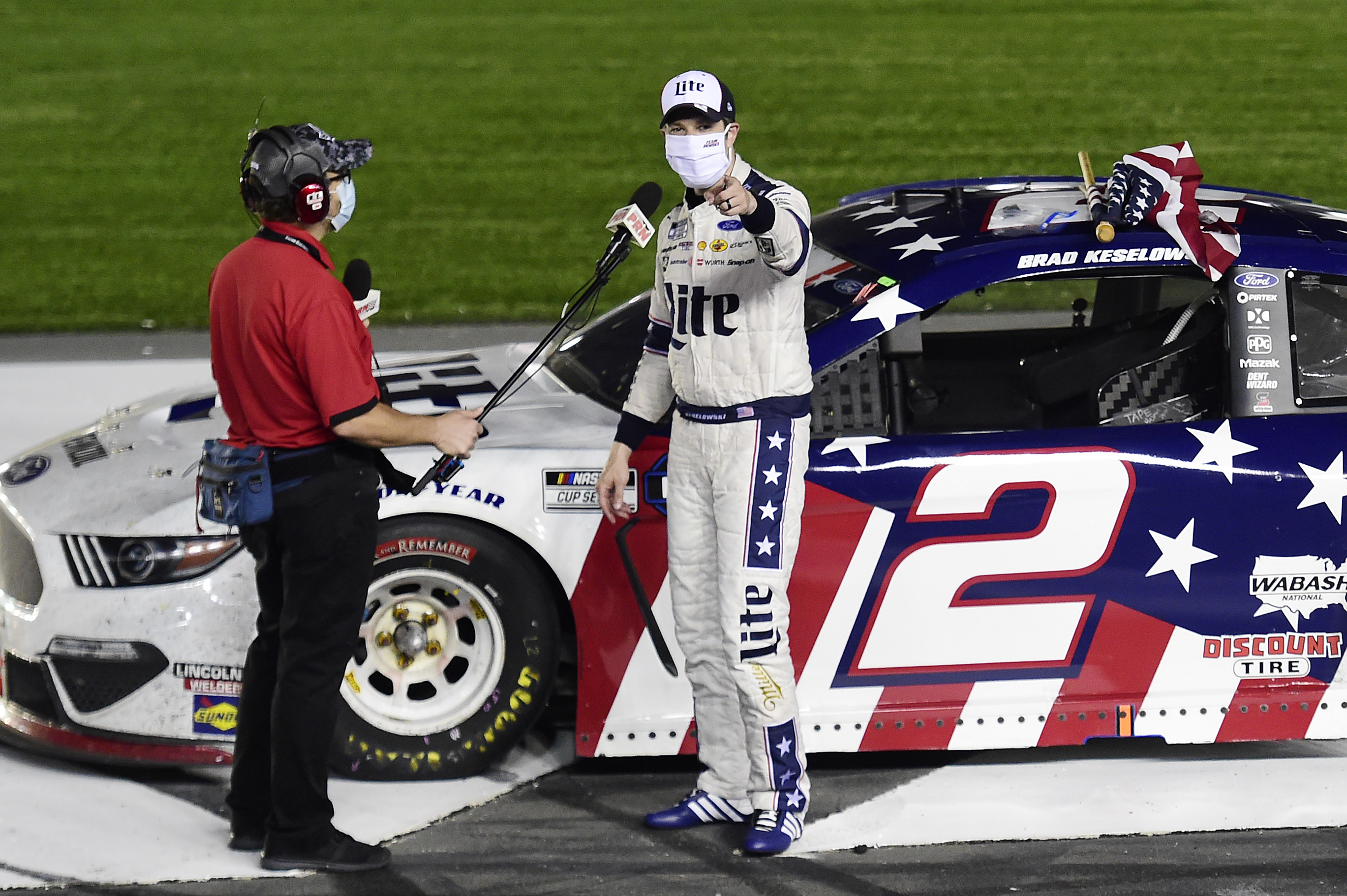 Brad Keselowski, driver of the No. 2 Penske Racing Ford, conducts a socially-distant winner's interview after his victory in NASCAR's longest race of the season, the Coca-Cola 600.