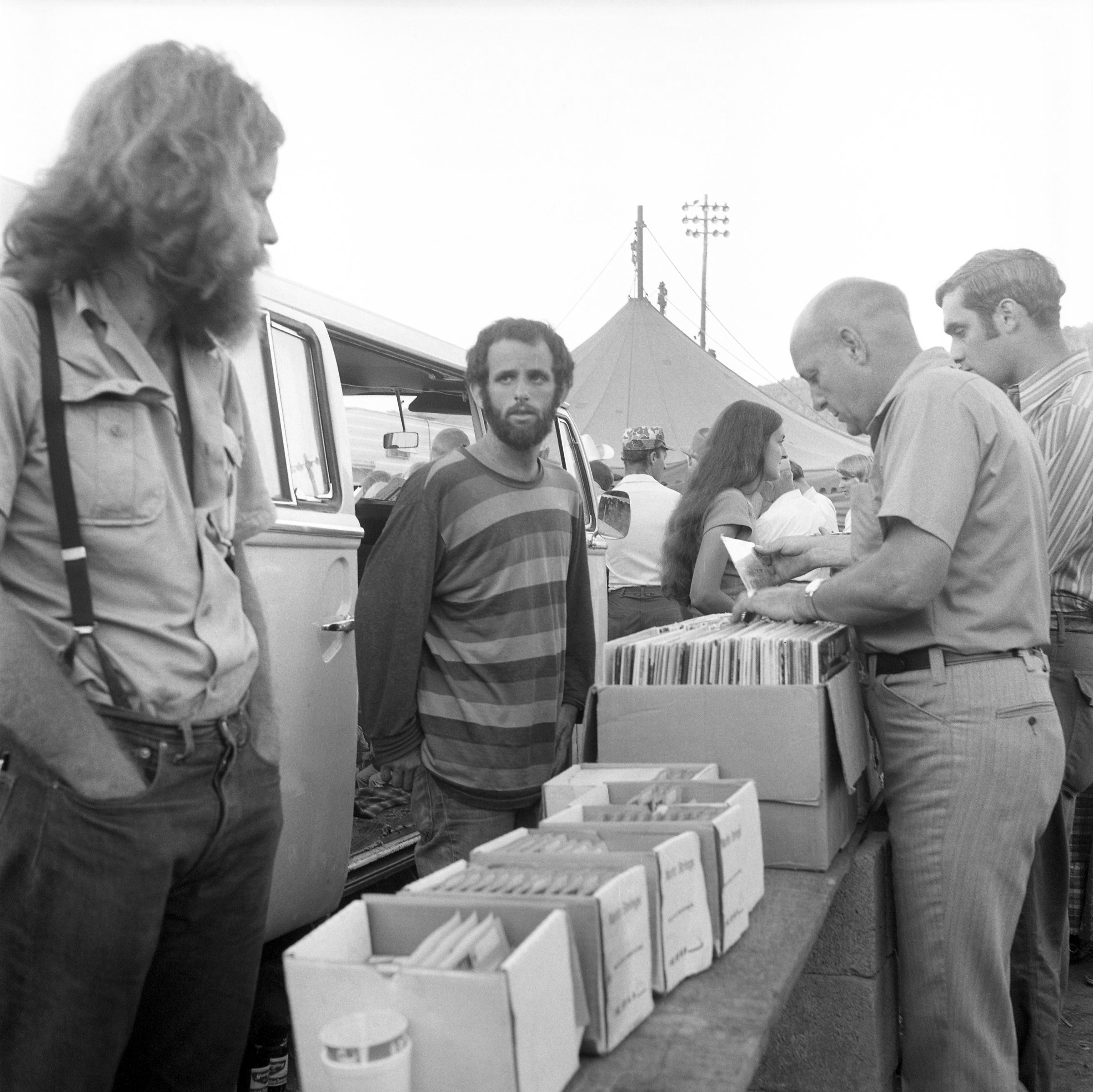 The three founders of Rounder Records -- Bill Nowlin, Ken Irwin, and Marian Leighton Levy -- selling records out of the back of a VW bus.