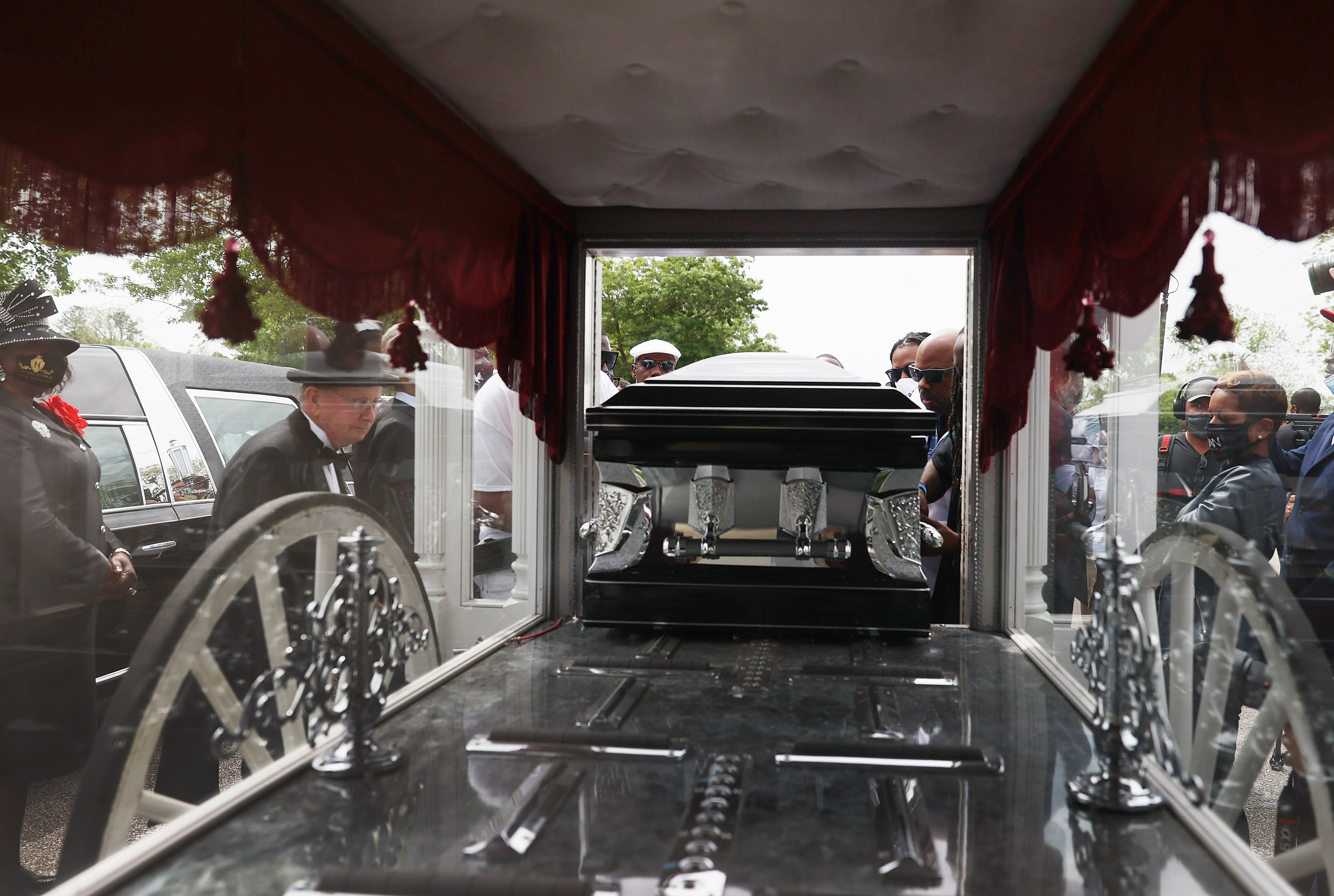 Pallbearers placed the casket of Andrew Brown Jr. into a horse drawn carriage before his funeral service.