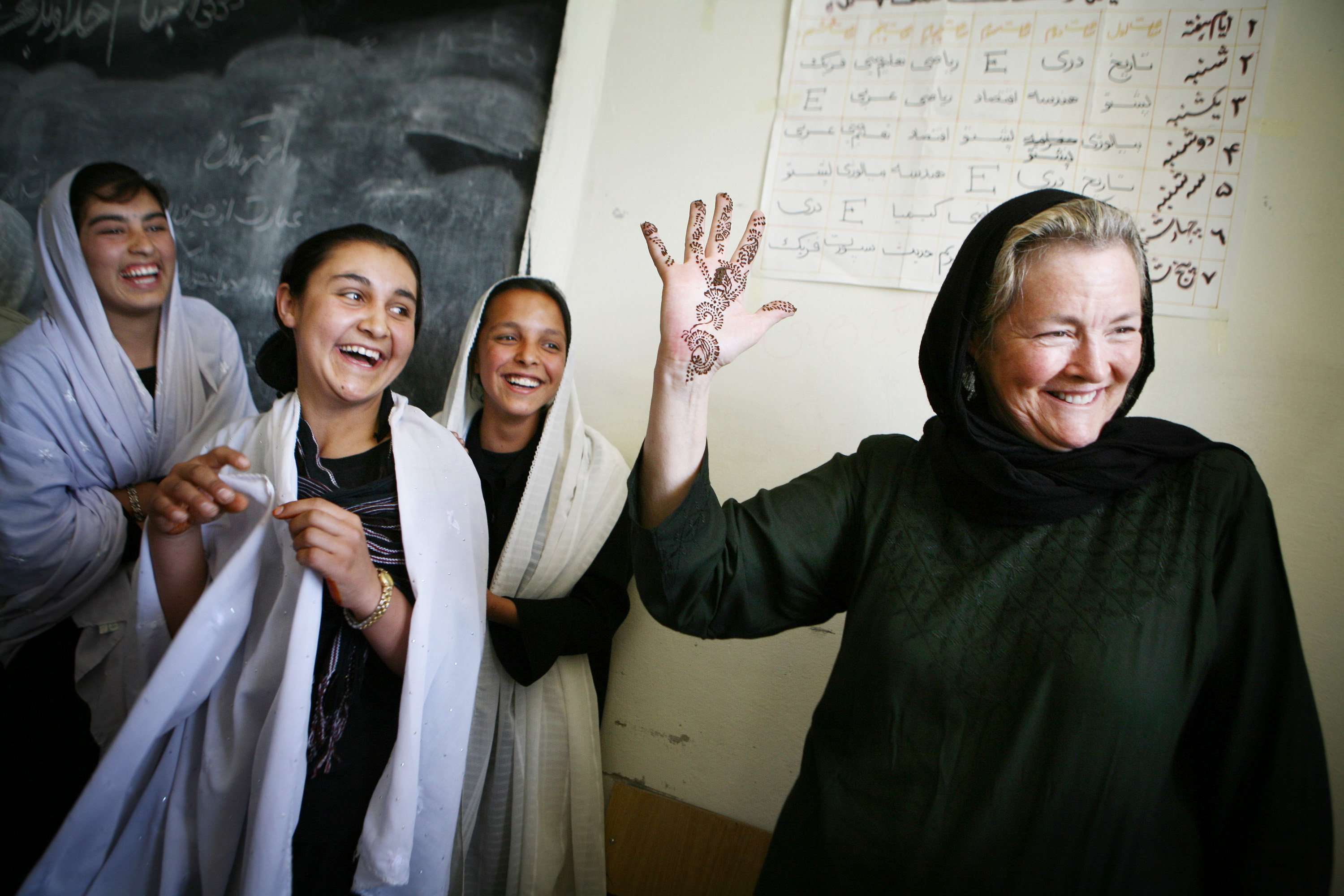 Sally Goodrich (right) showed a henna painting she received from an Afghan student at the school her family sponsored.