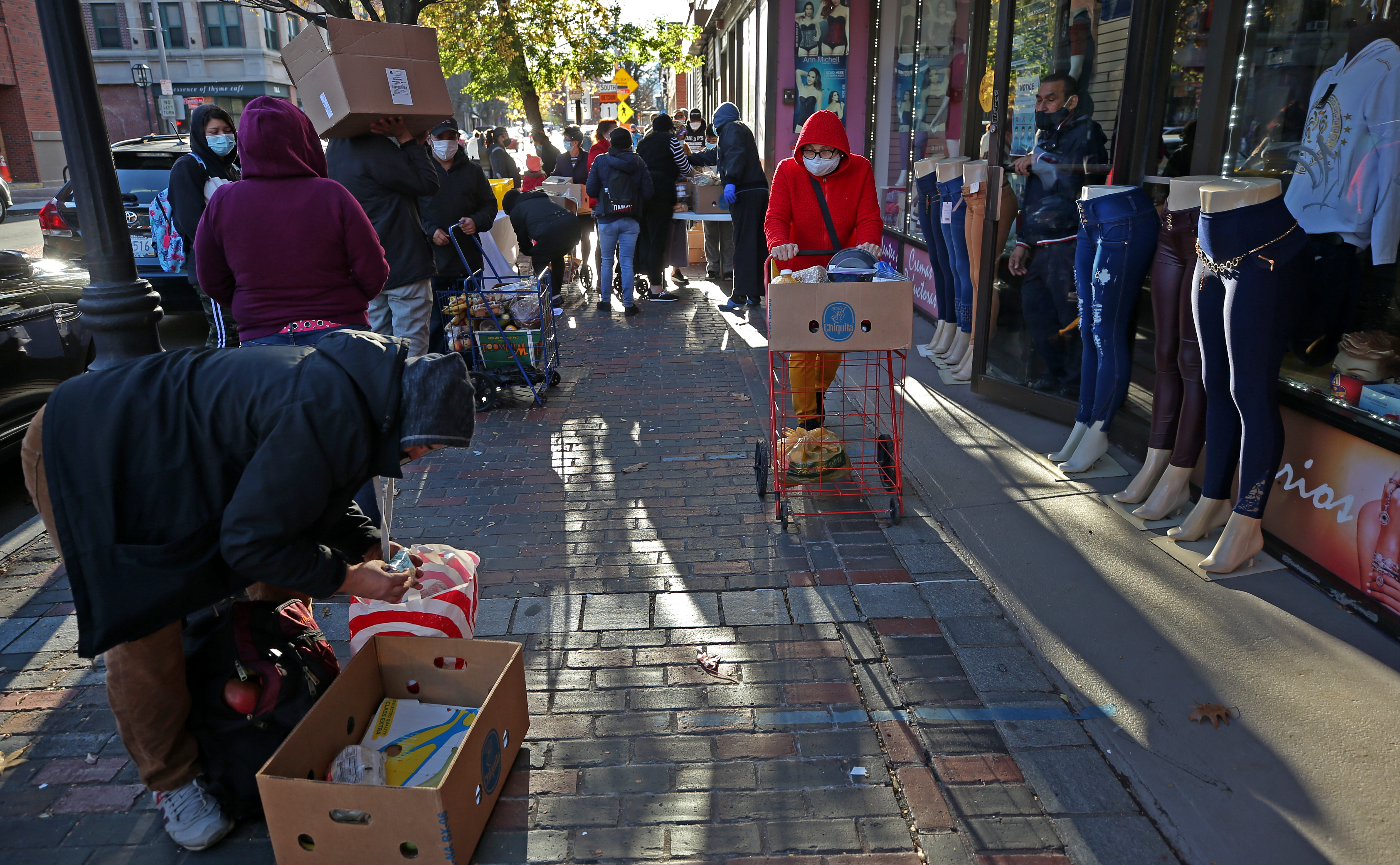 A man repacked the food he got from a food pantry on Broadway in Chelsea. Chelsea has been one of the places in Greater Boston hardest hit by the pandemic.