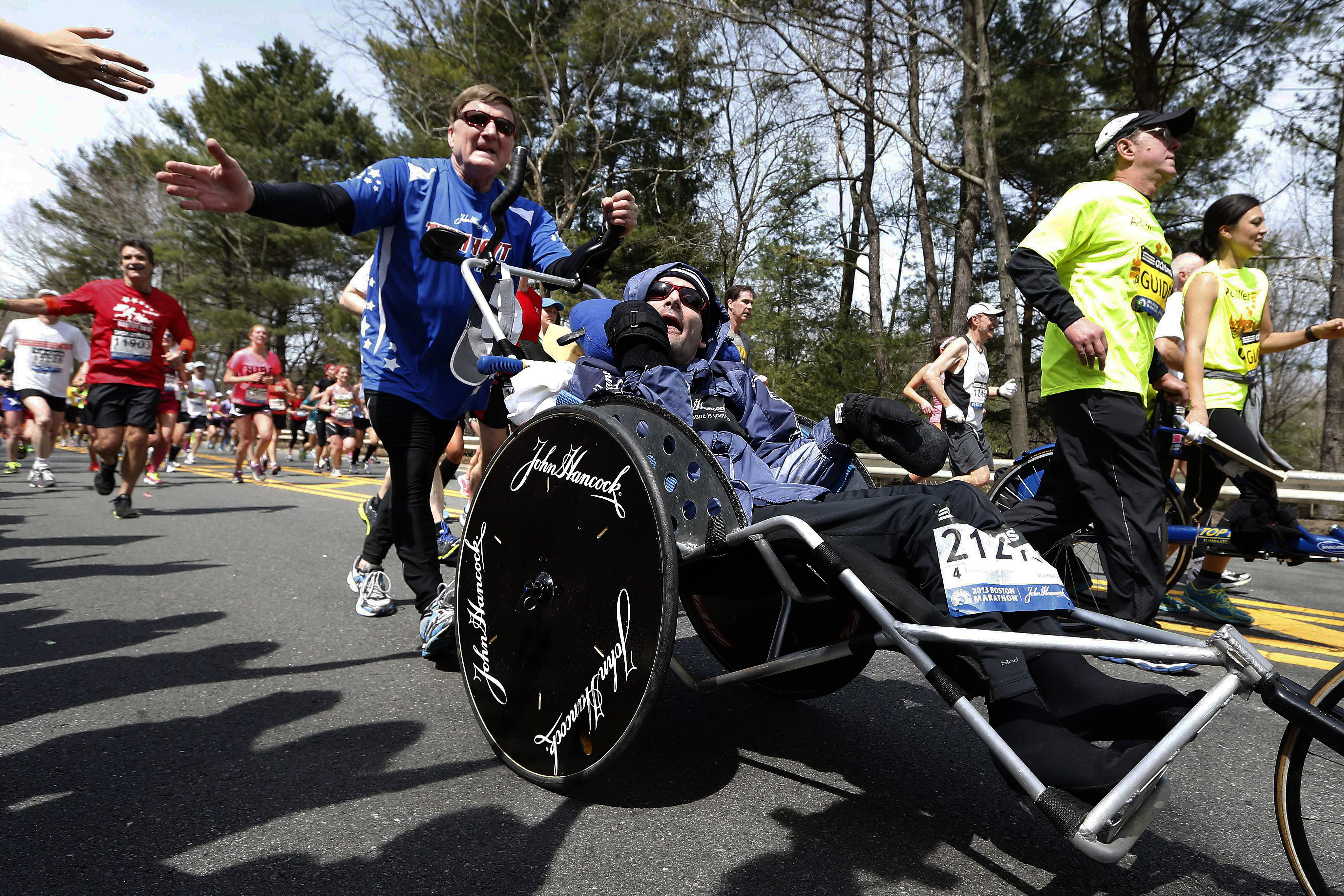 En esta foto de archivo del 15 de abril de 2013, Dick Hoyt, a la izquierda, empuja a su hijo Rick por la pista del maratón de Boston en Wellesley.