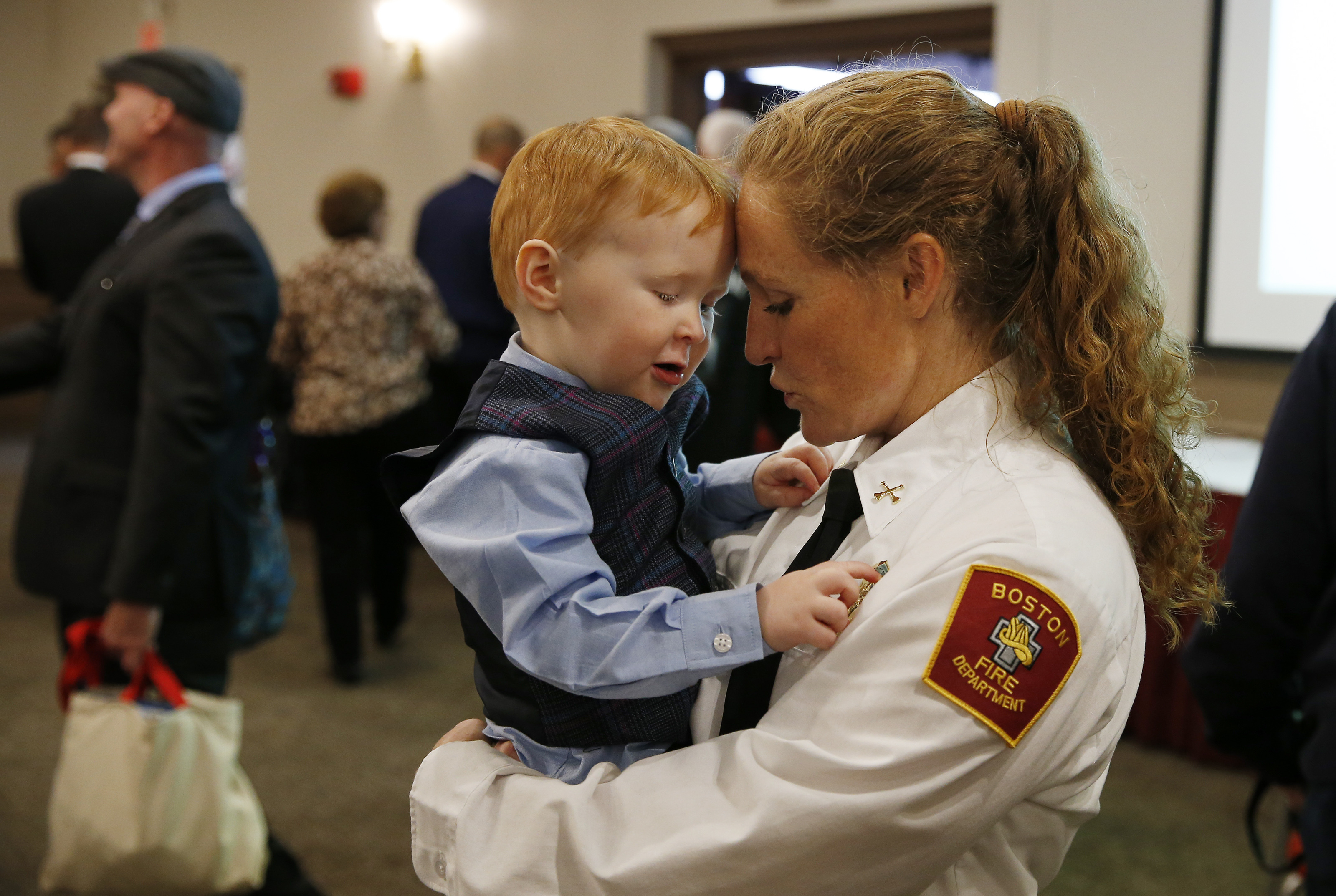 Deanna McDevitt held her 2-year-old son, Tommy, after her promotion to district fire chief. She is the first woman district fire chief in the history of the Boston Fire Department.