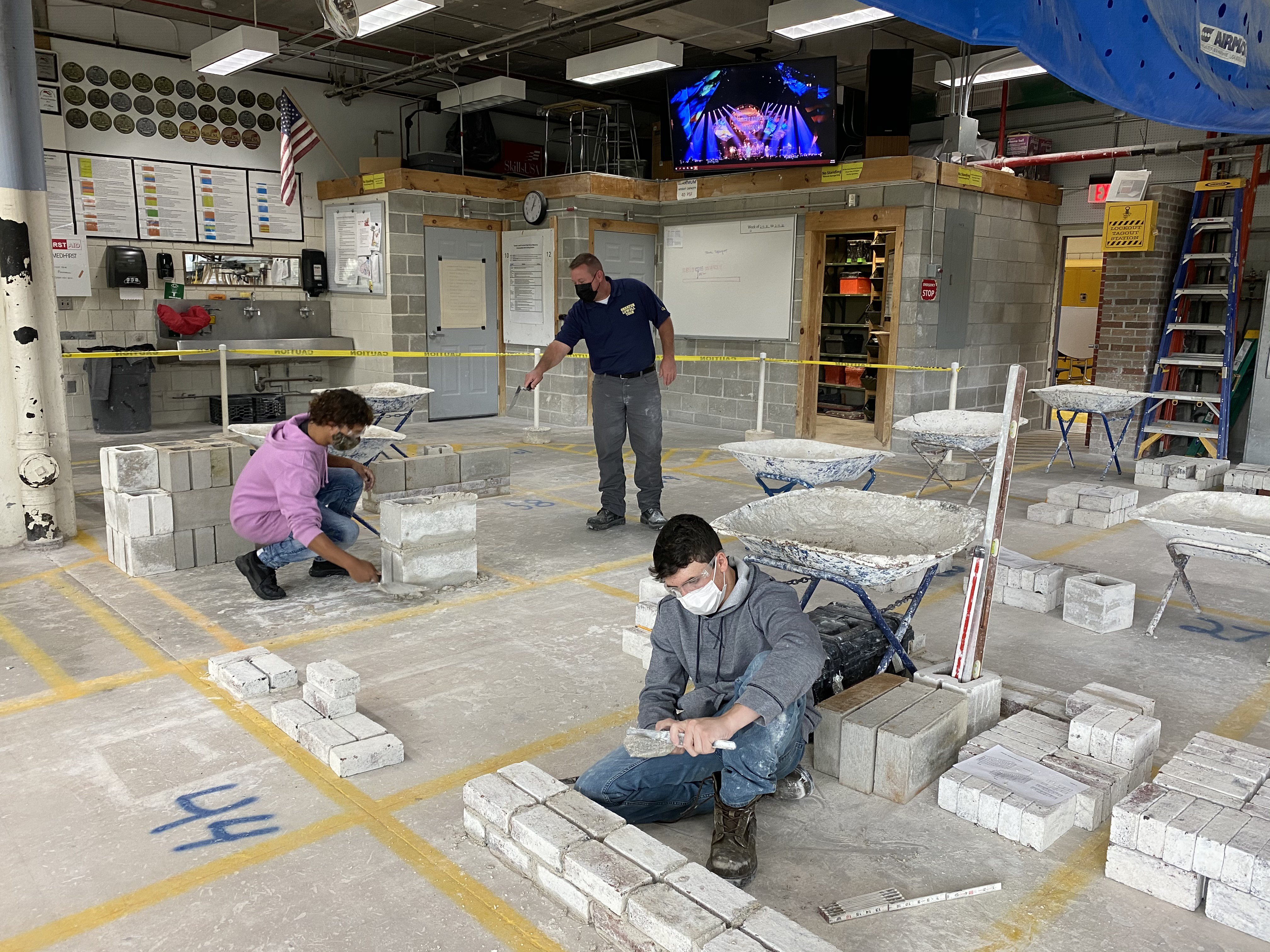 A masonry workshop class at Greater Lowell Technical High School.  From left to right, Yan Ortiz, grade 10, of Lowell;  teacher Jay Foster;  and Eric Brière, Grade 11 from Tyngsborough. 