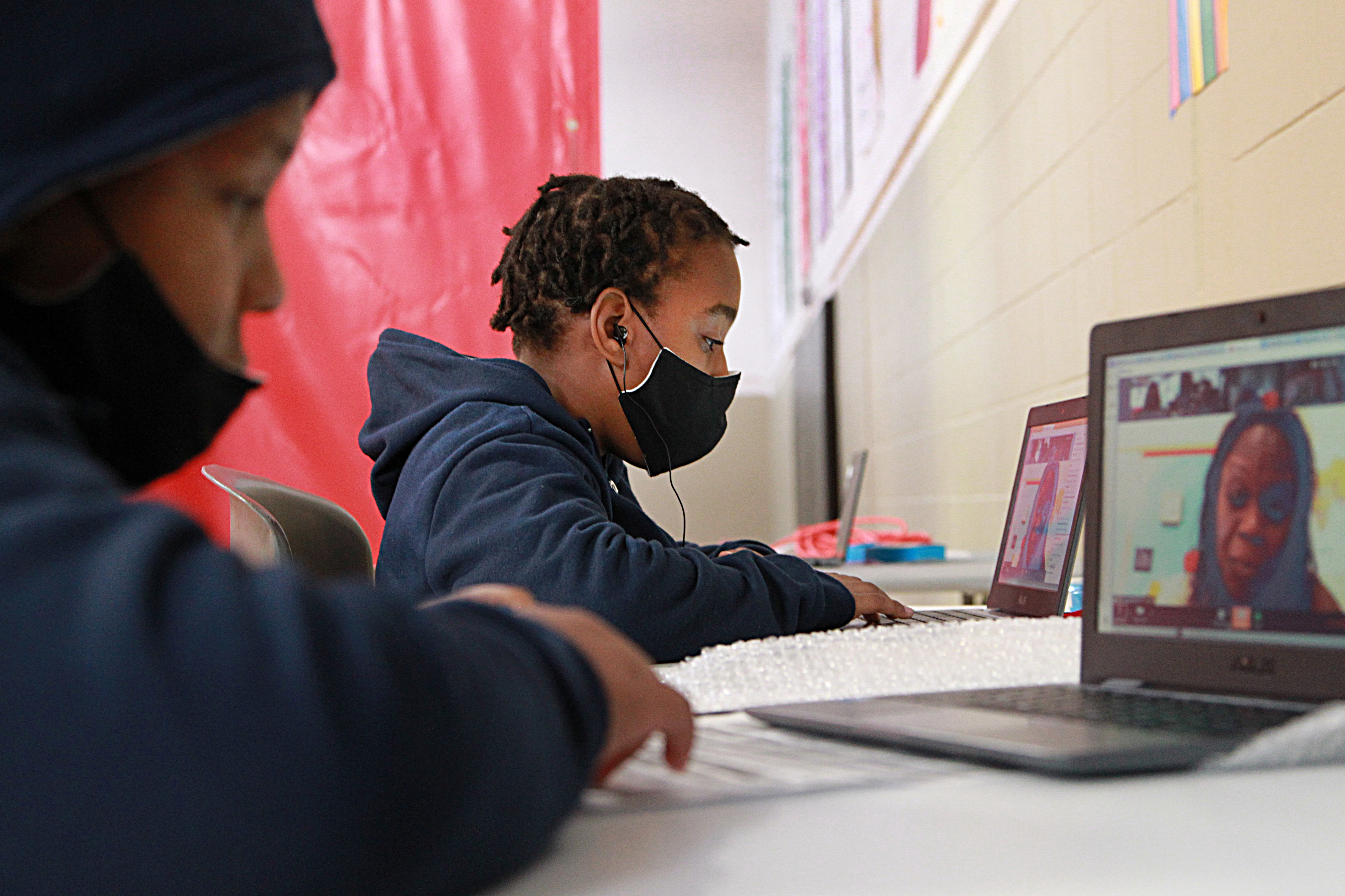 Eleven-year-old twins Tyreke and Tyrelle Satchebell did their remote learning at the Roxbury YMCA on Monday.