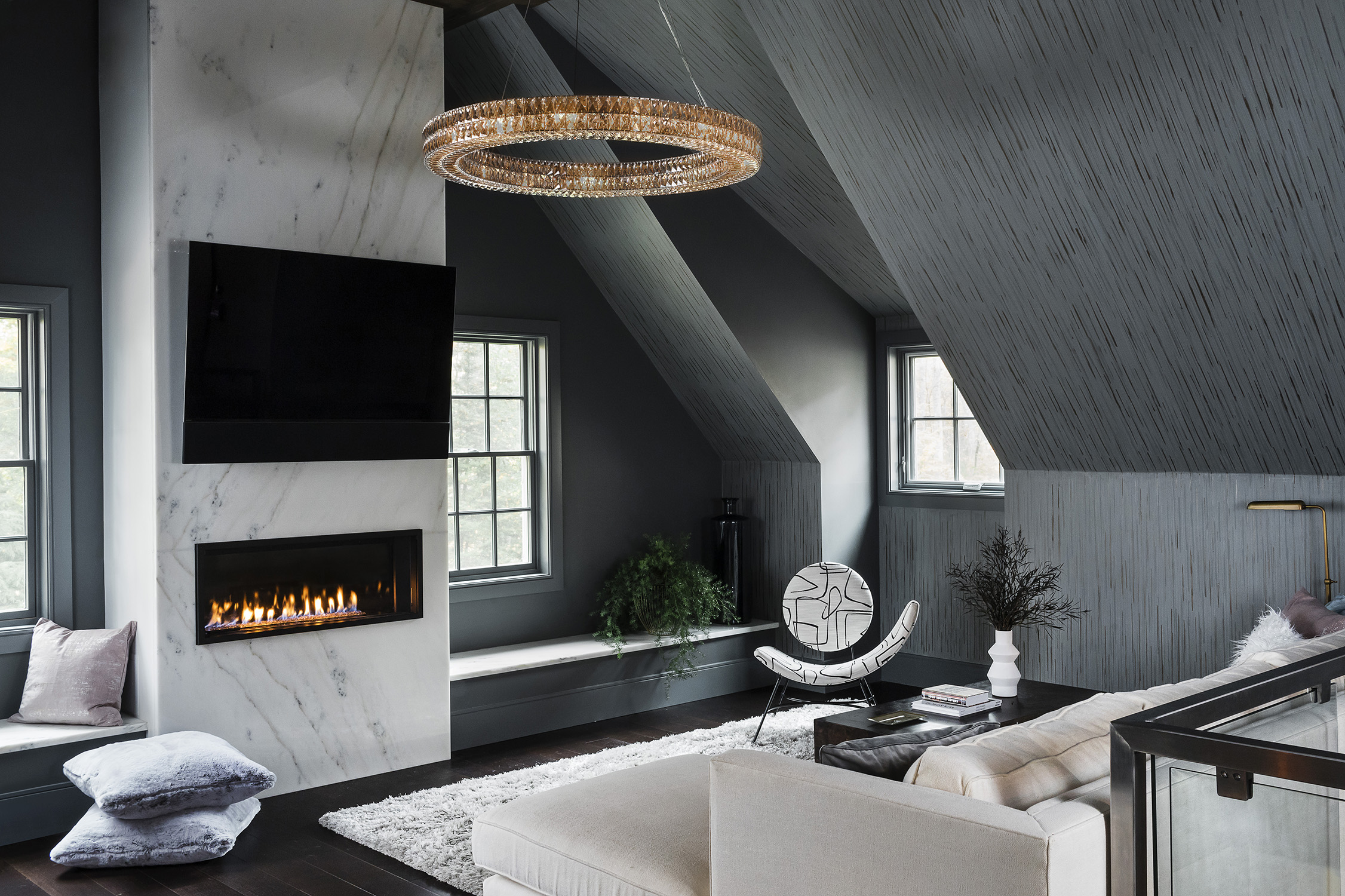 By the gas fireplace, clad in book-matched marble, a shaggy Surya rug is low-maintenance but still looks luxe.