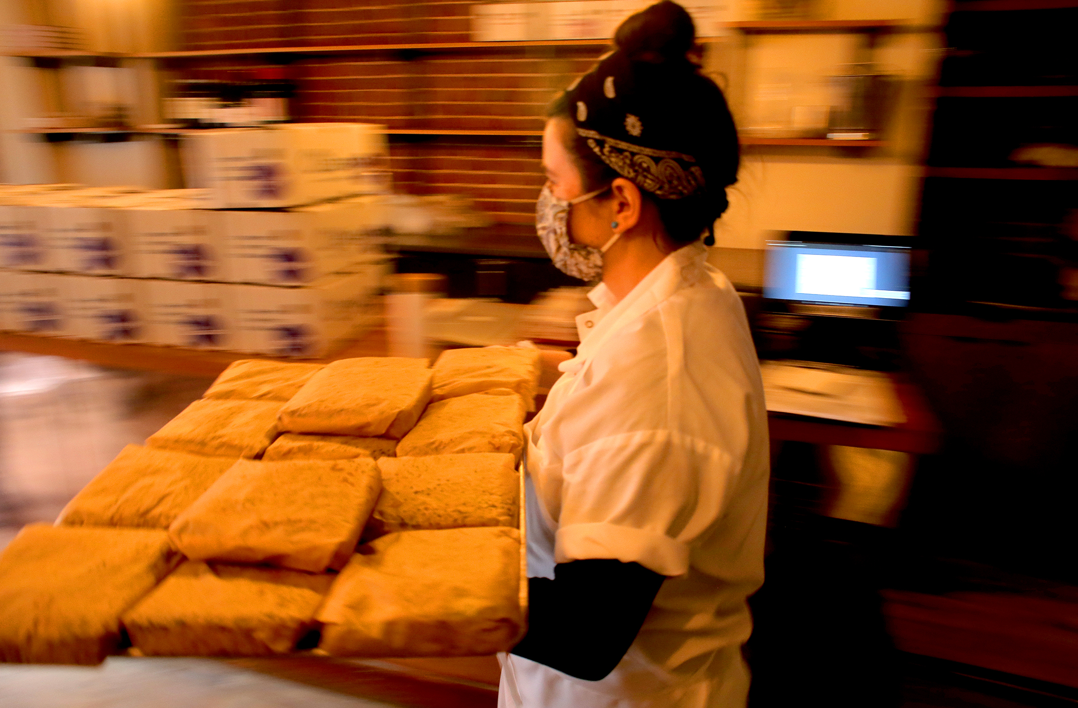 Pastry chef Sophie Gees carries bread she made earlier to add to the boxes.