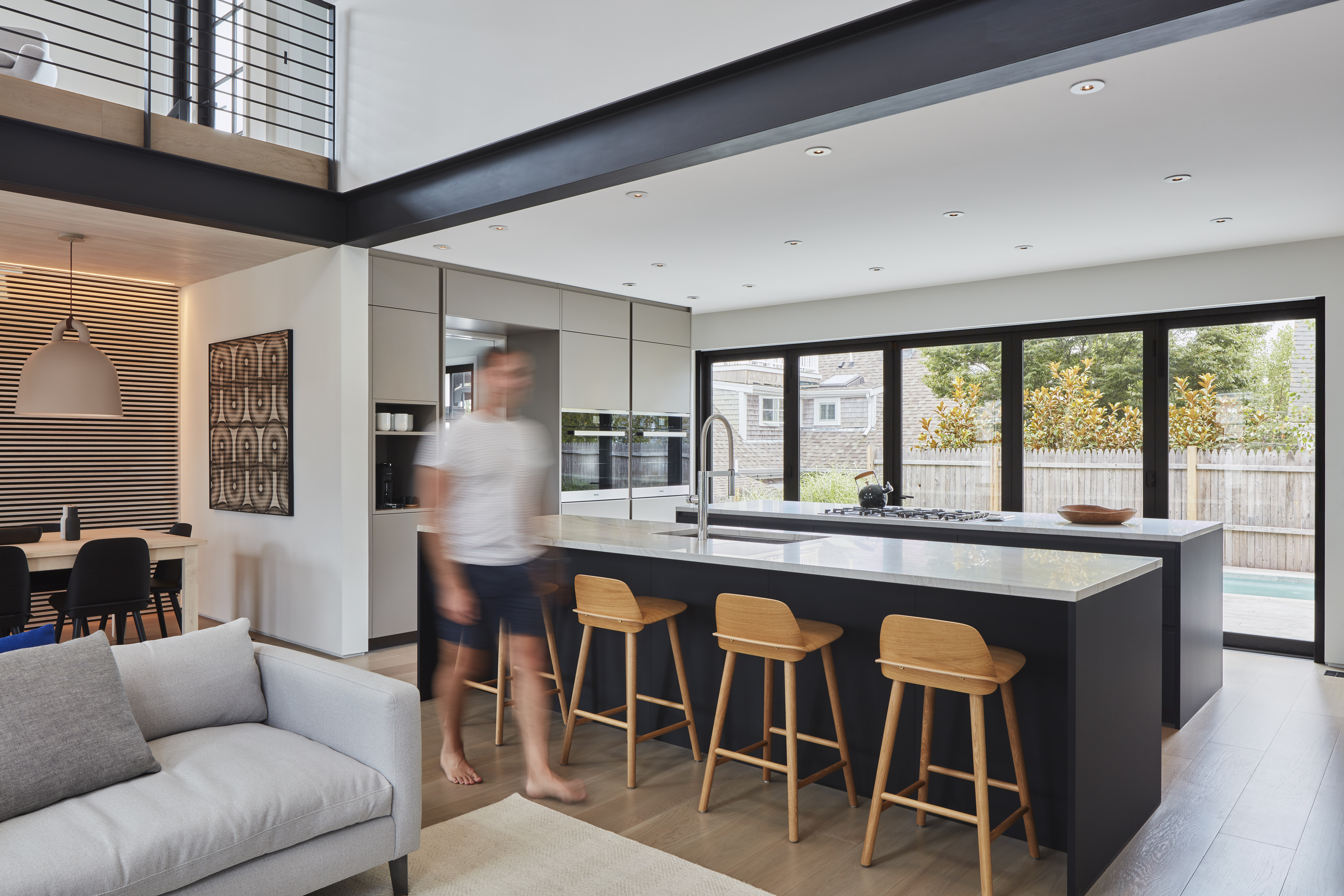 A contrasting color on the kitchen islands draws the eye to the kitchen
without obstructing the outside view.