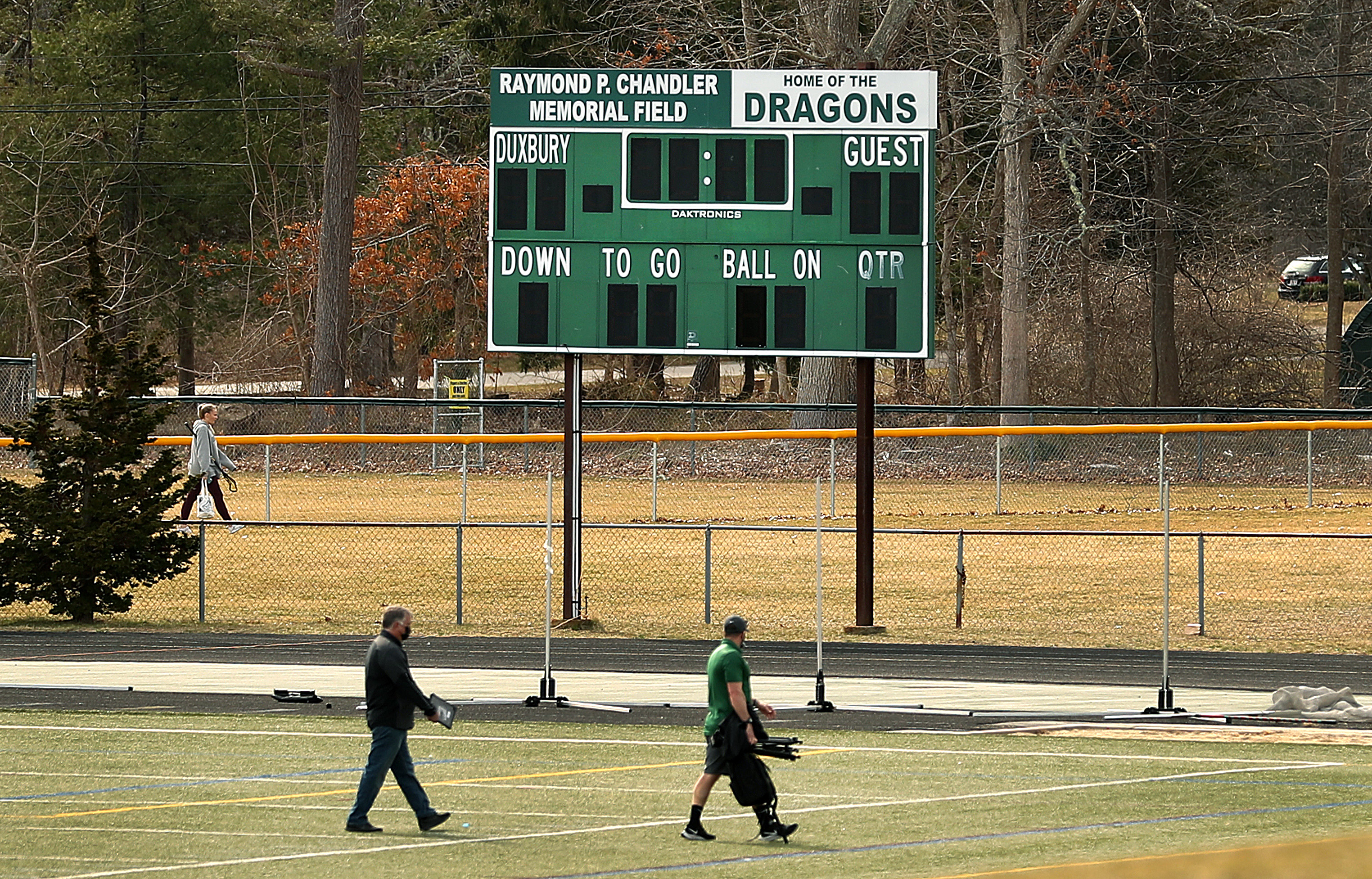 Two men crossed the Duxbury High School football field.