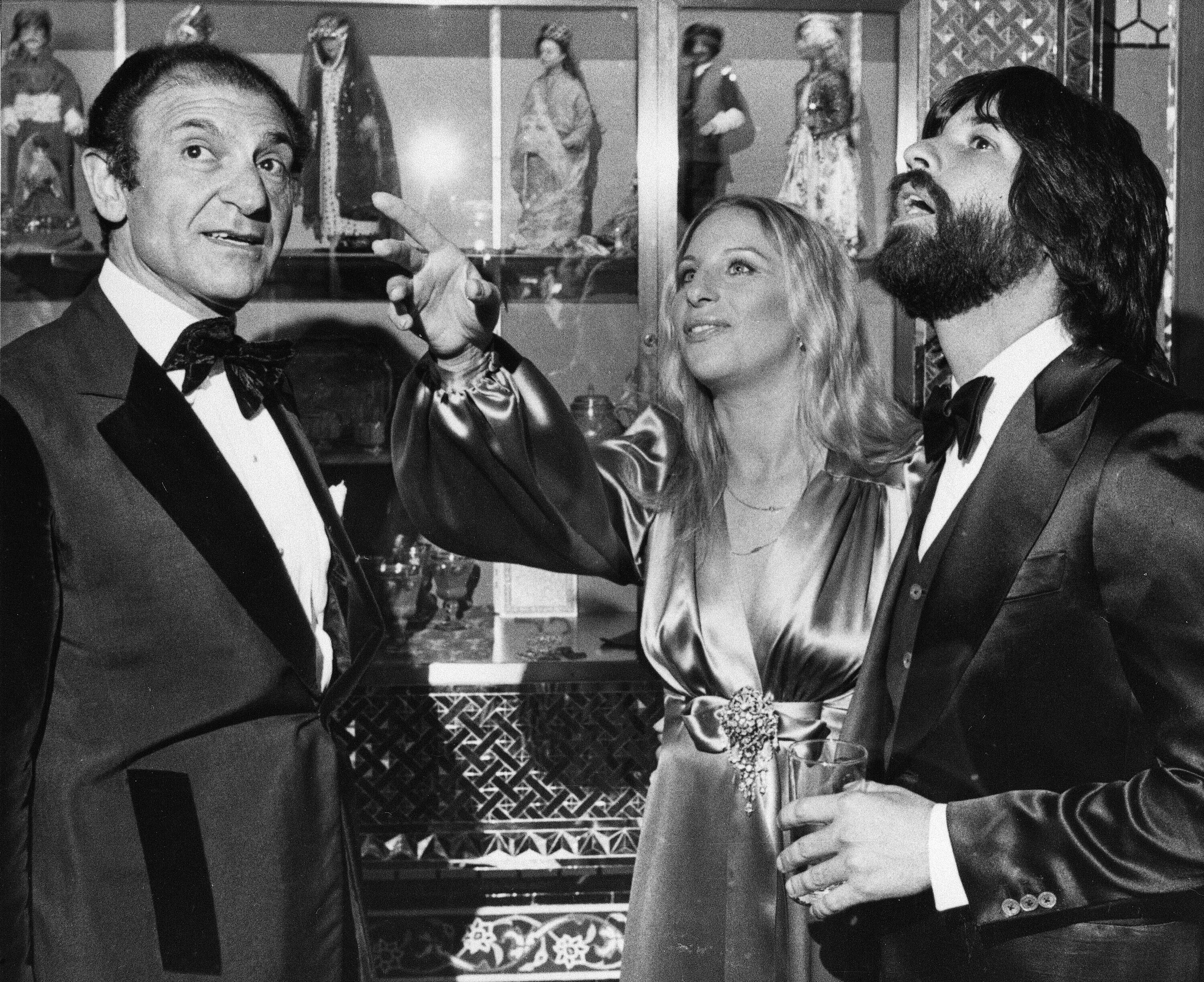 Mr. Zahedi (left) talked with actress Barbra Streisand and her escort Jon Peters as they admired the Iranian Embassy during a 1975 reception in Washington, D.C.