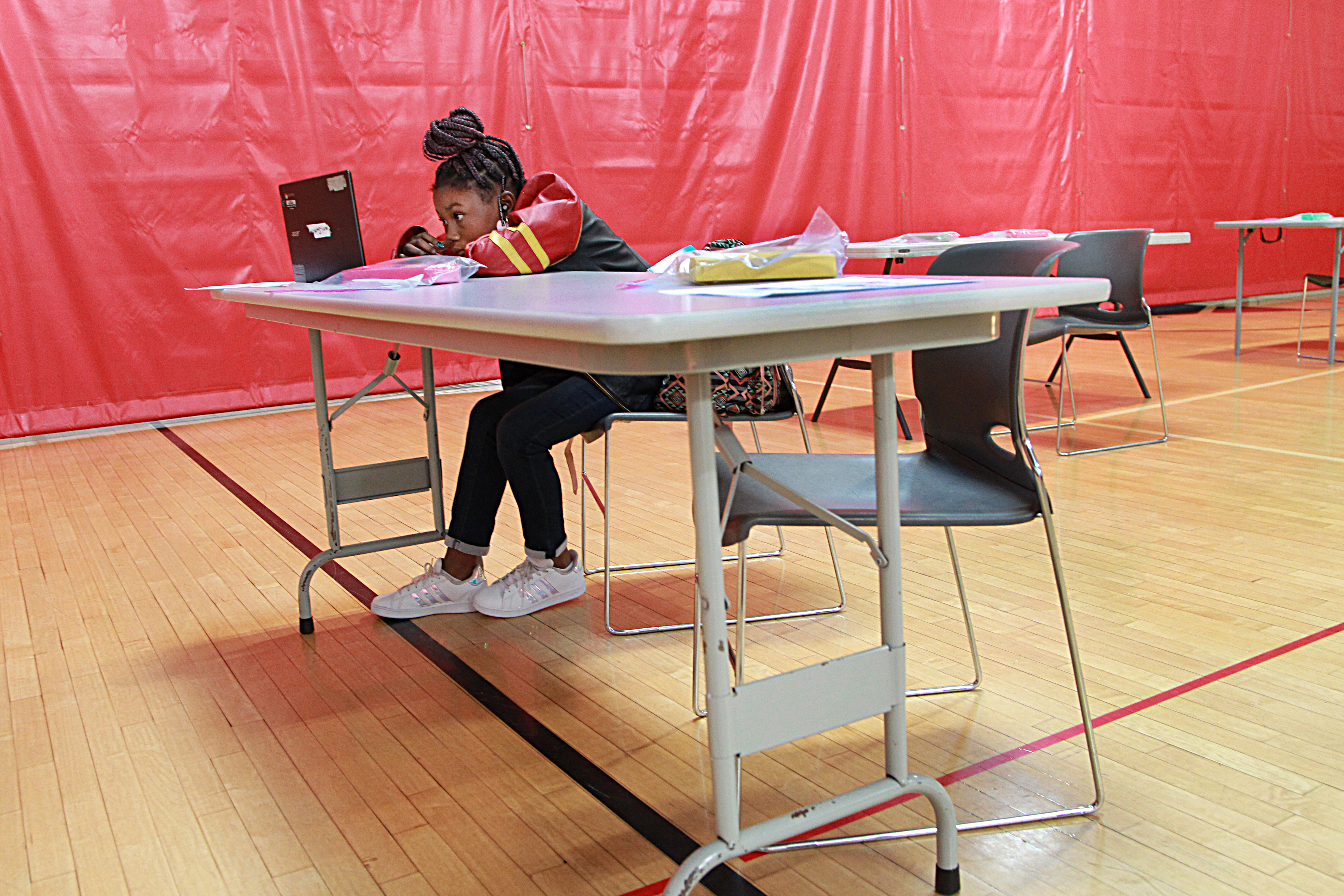 Nine-year-old Myarri Smith-Knight worked in the gym of the Roxbury YMCA. Boston Public Schools students learned remotely on their first day of school at the Roxbury YMCA on Monday. The Roxbury Y is among nearly 100 programs across Boston providing school-day space while public schools are closed for more than 6,000 students so their parents can work and the students can receive help, be supervised, and have fun playing with other kids.