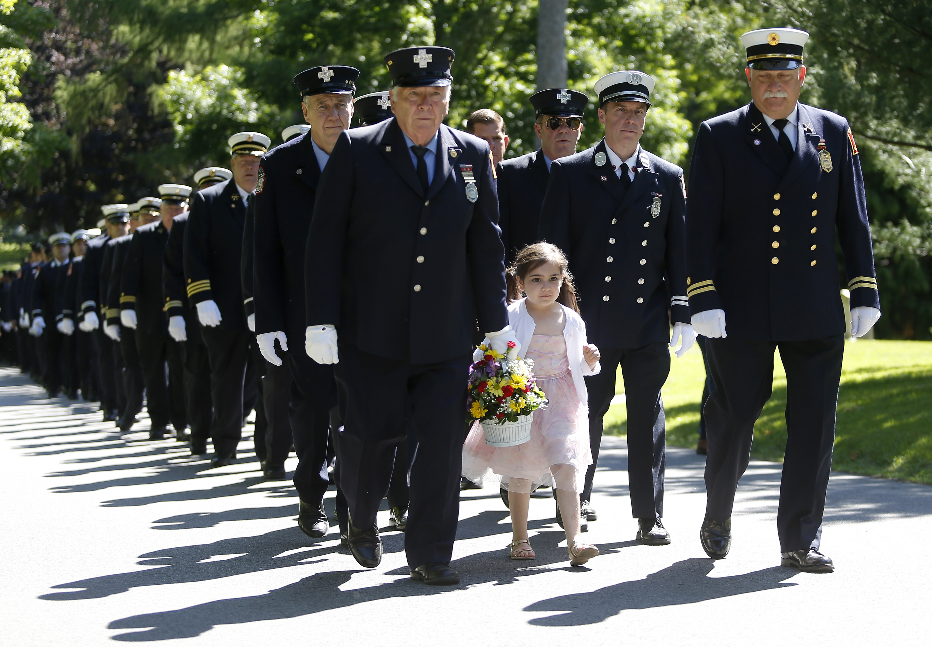 Paige Kapadia, 4, marched with her grandfather, retired Boston firefighter Dave Johnson, during the annual procession to the Firefighters Memorial Service at Forest Hills Cemetery in Jamaica Plain on June 9.