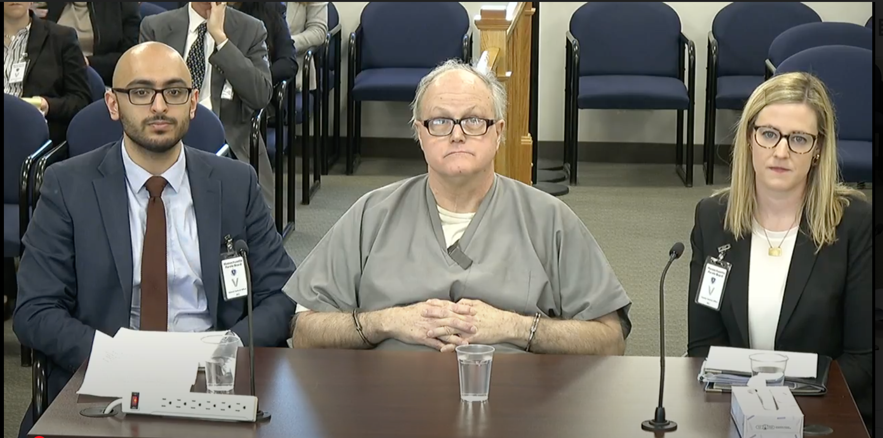 Wilfred Dacier in 2020, flanked by student lawyers during a parole hearing.