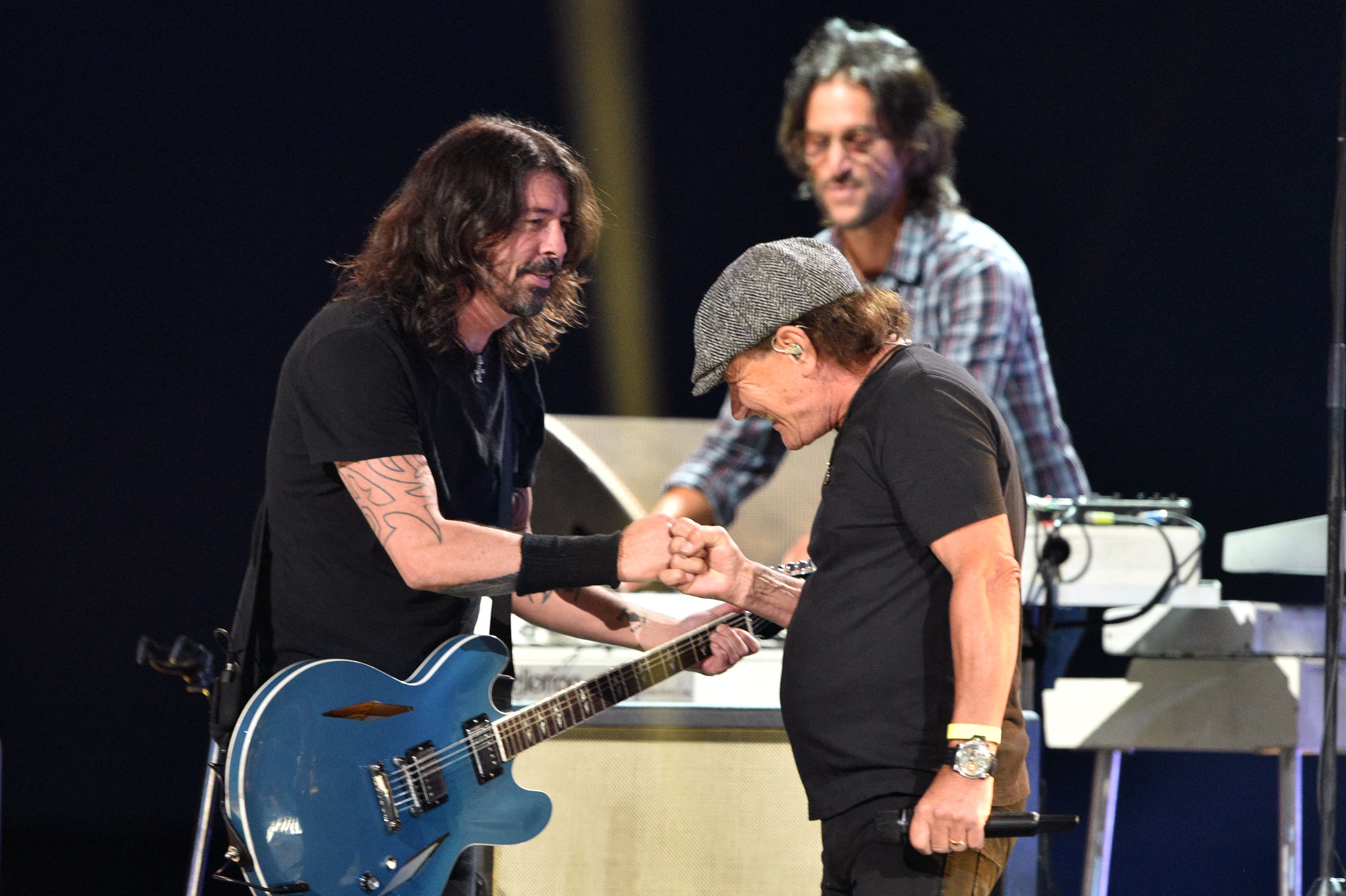 Brian Johnson of AC/DC (right) bumped fists with Dave Grohl of the Foo Fighters after performing with them onstage during the taping of the "Vax Live" fund-raising concert.