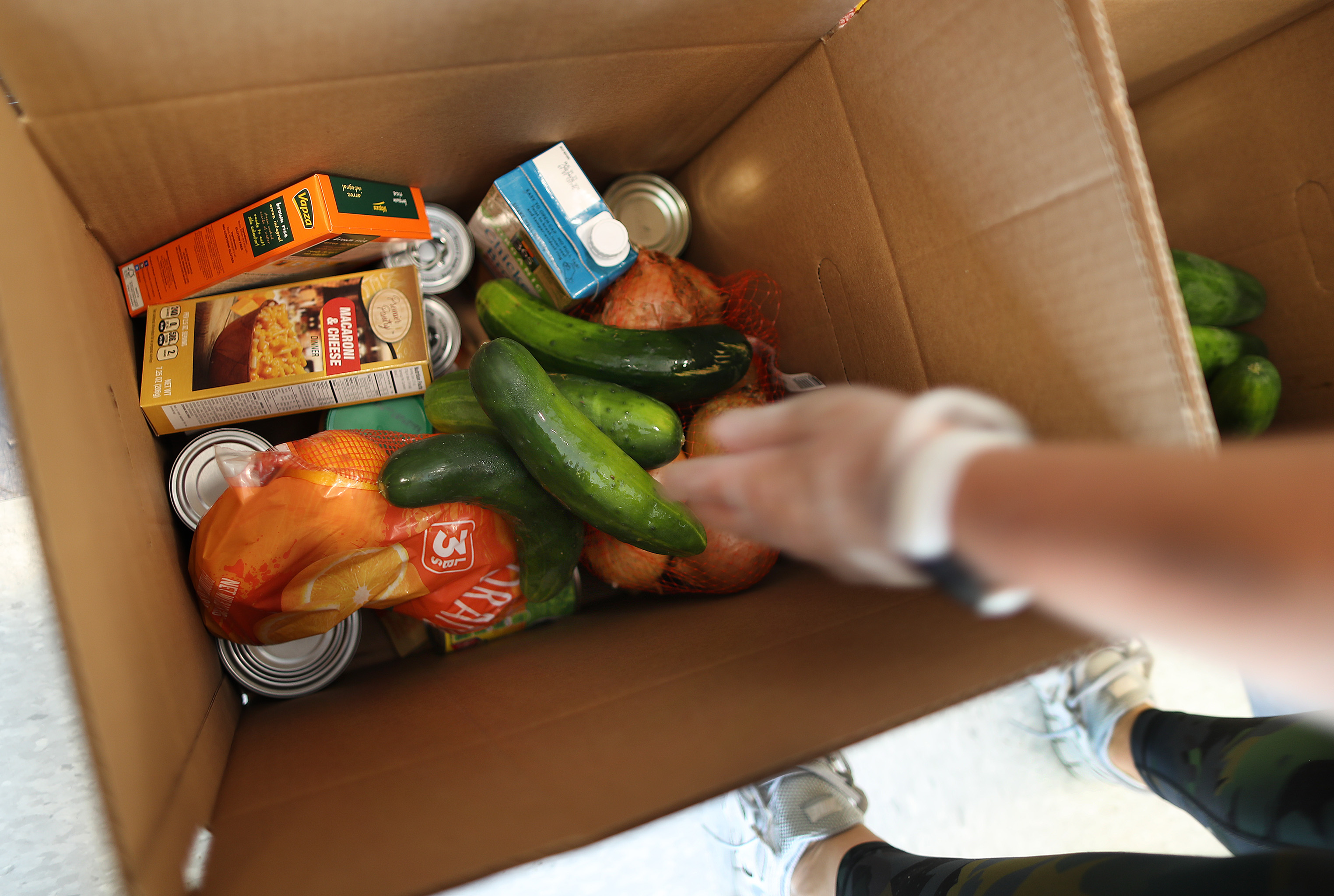 Caitlin Middaugh with the Malden YMCA gathers food for COVID-19 patients at the Walnut Street Center's Mystic Community Market. The food is loaded in boxes and delivered in the area to the COVID-19 patients who have specific diets.