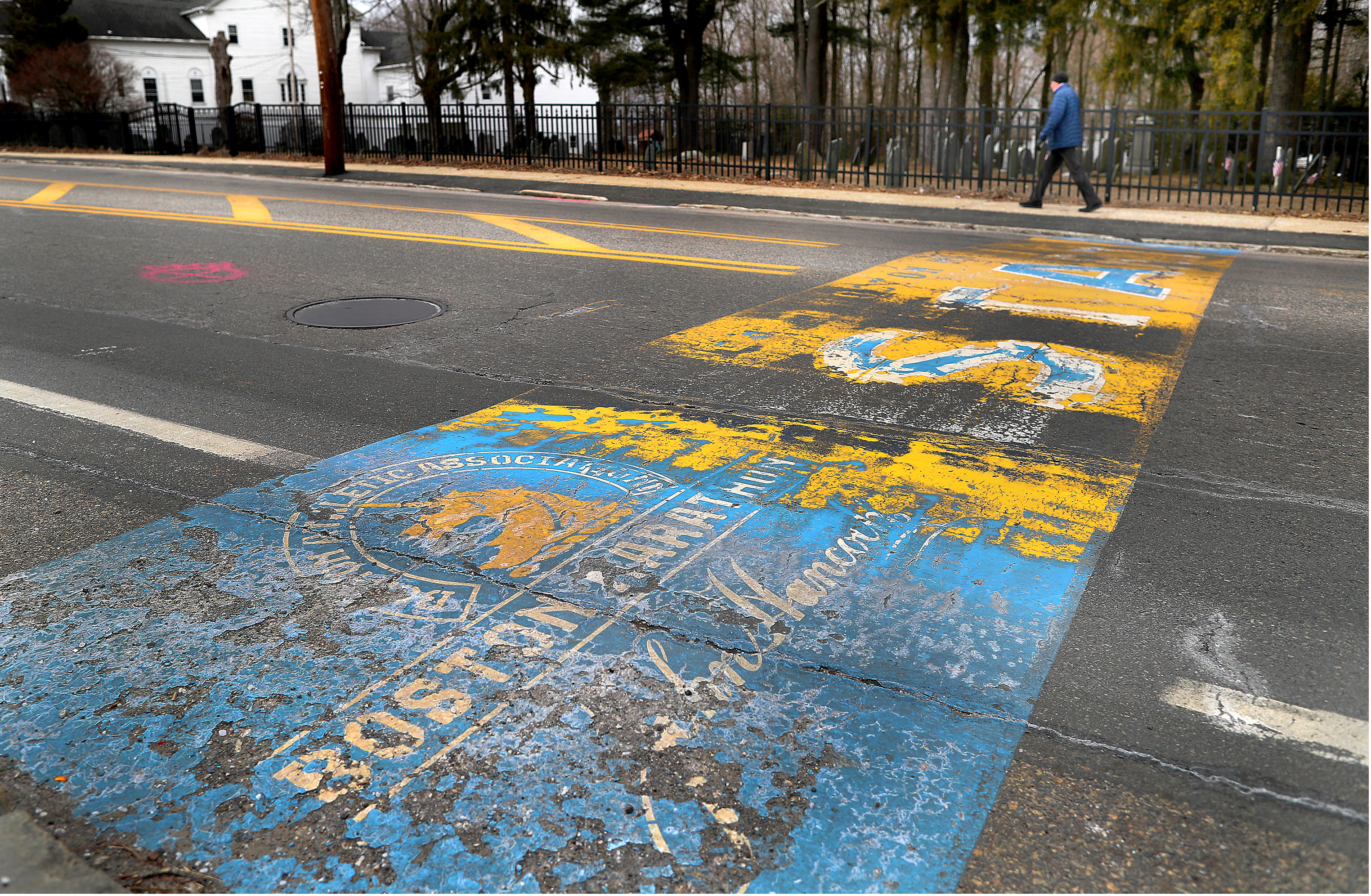 A man walked past the faded starting line of the Boston Marathon on Main Street in Hopkinton on Tuesday.