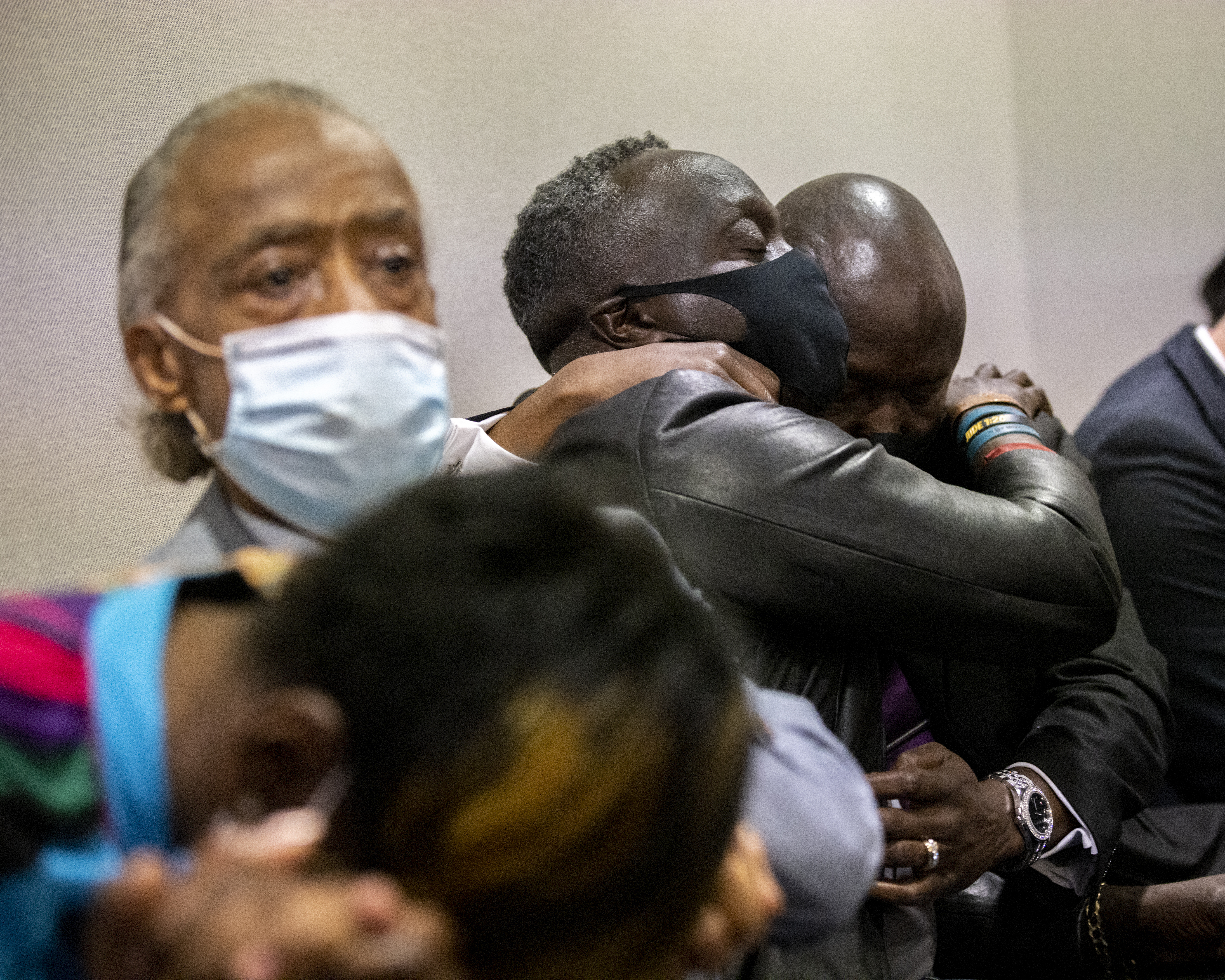 Ahmaud Arbery's father Marcus Arbery, center, hugged by his attorney Benjamin Crump after the jury convicted Travis McMichael in the Glynn County Courthouse, on Wednesday.