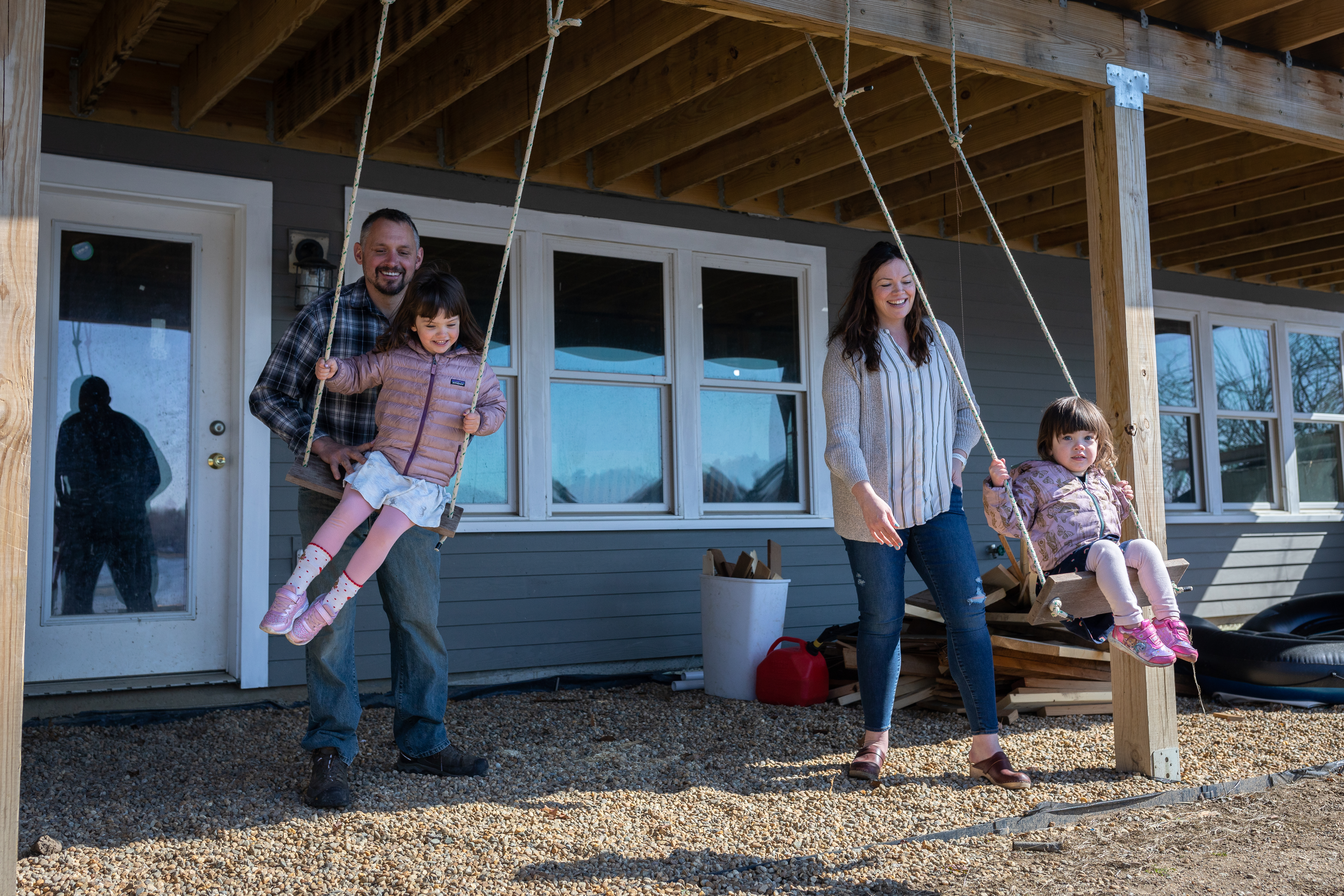 Mike and Emily Broderick push their daughters, Rowan and Cora, on swings they fastened to the underside of the deck they built.