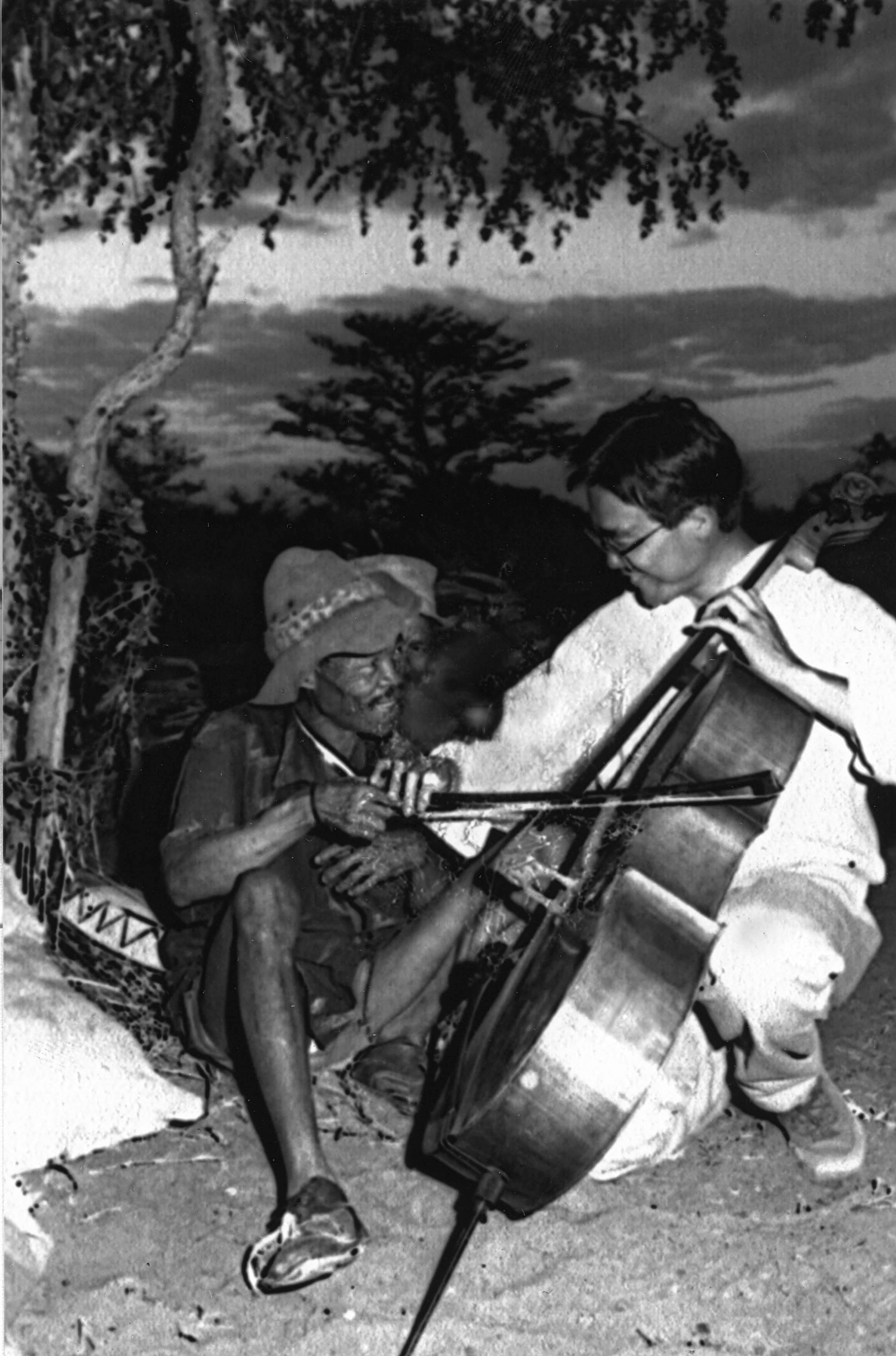 Yo-Yo Ma demonstrates his cello for a listener in the Kalahari Desert.