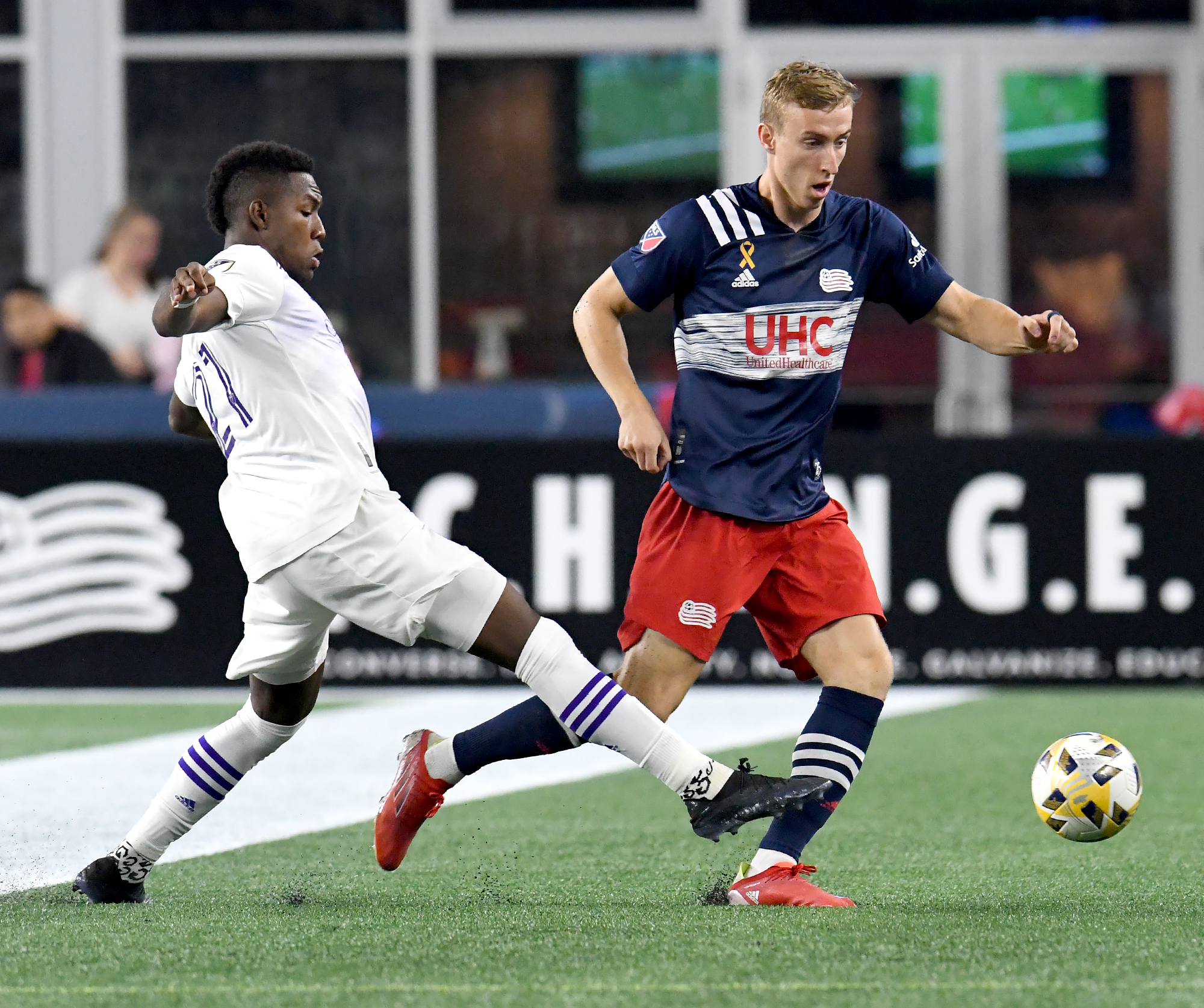 Adam Buksa (right) tries to out maneuver Orlando City's Andres Perea as the league-leading Revolution won Saturday night at Gillette Stadium.