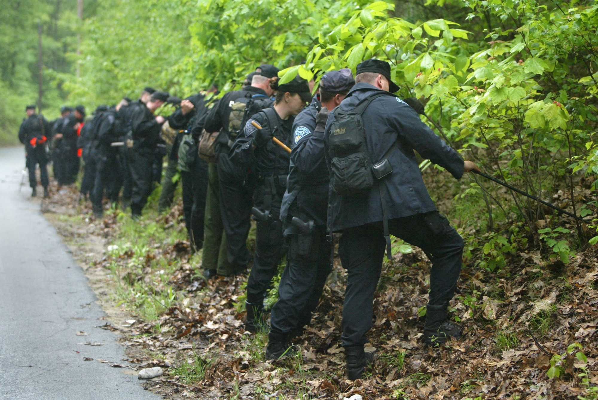 Massachusetts State Police Troopers and Environmental Police officers searched in tight formation in this Monday, June 9, 2003 file photo, for evidence in the disappearance of Molly Bish. On Thursday, Worcester District Attorney Joseph D. Early Jr. named Francis Sumner Sr., of Spencer, who died in 2016, as a person of interest in the case.
