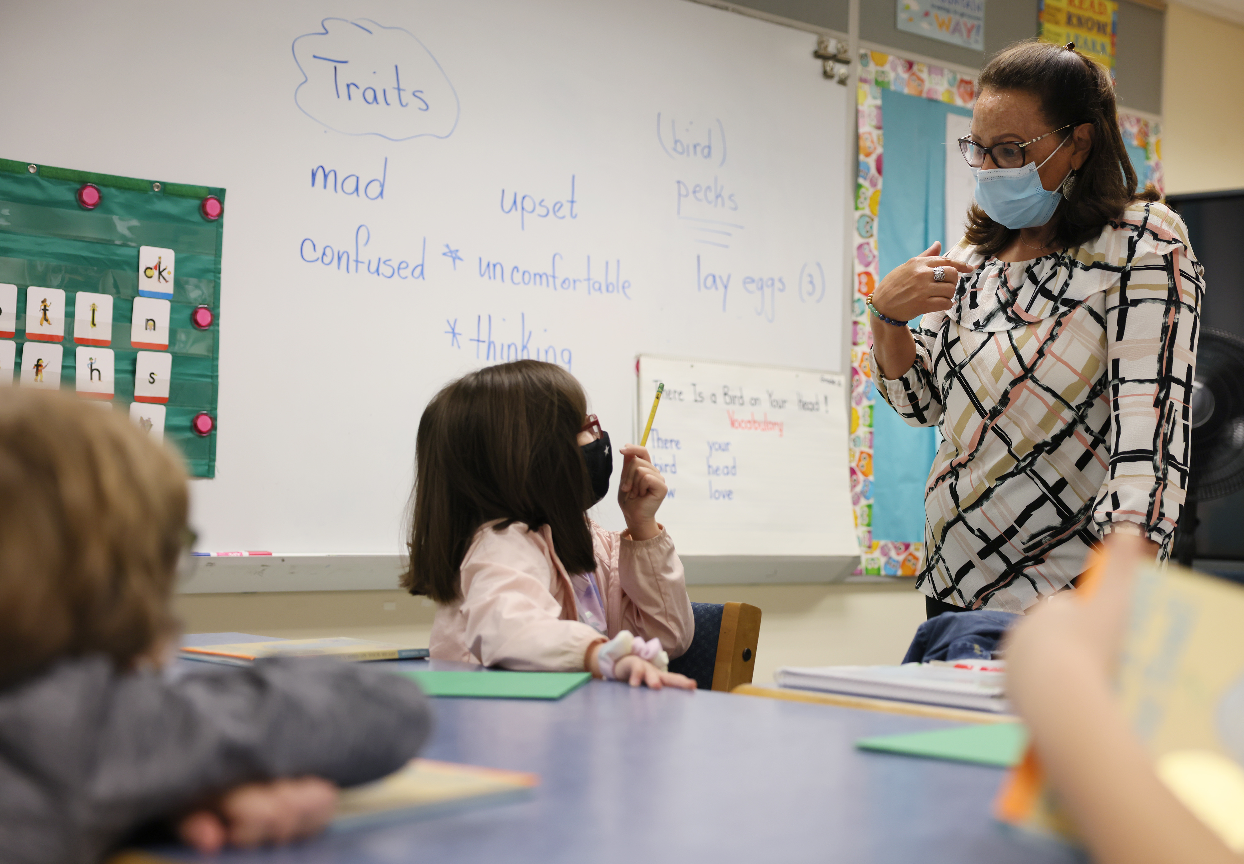 Minerva Tirado asks her first-grade students to discuss the traits of the main character in the book that they are reading as she tutors them at Pyne Arts Magnet School, on Sept. 28. Lowell Public Schools has used federal coronavirus relief funds to hire more "tutors" to work with small groups of students during class to help students who have fallen behind after remote learning.