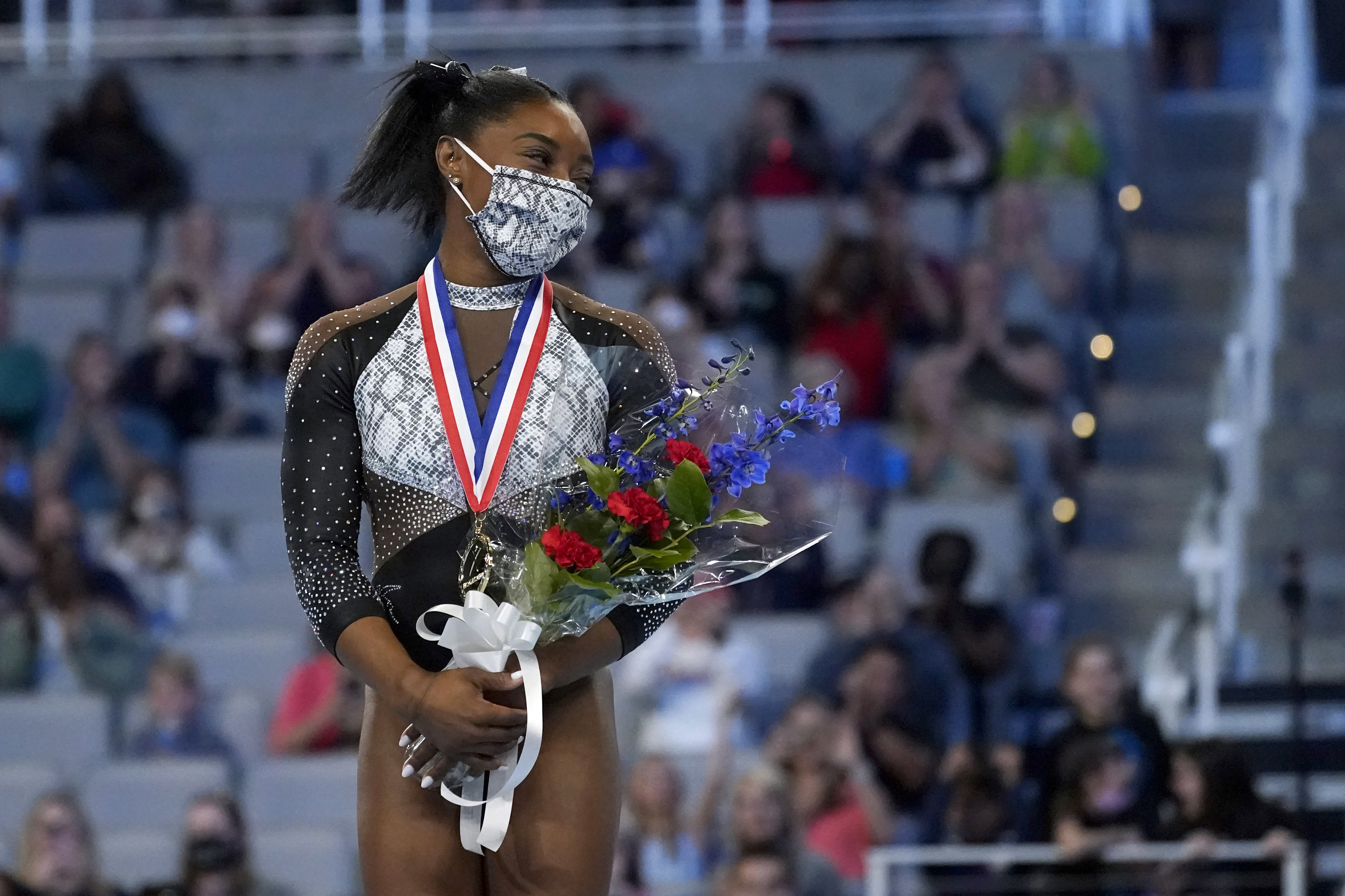 Simone Biles stands on the podium after winning first place in the all around Sunday.
