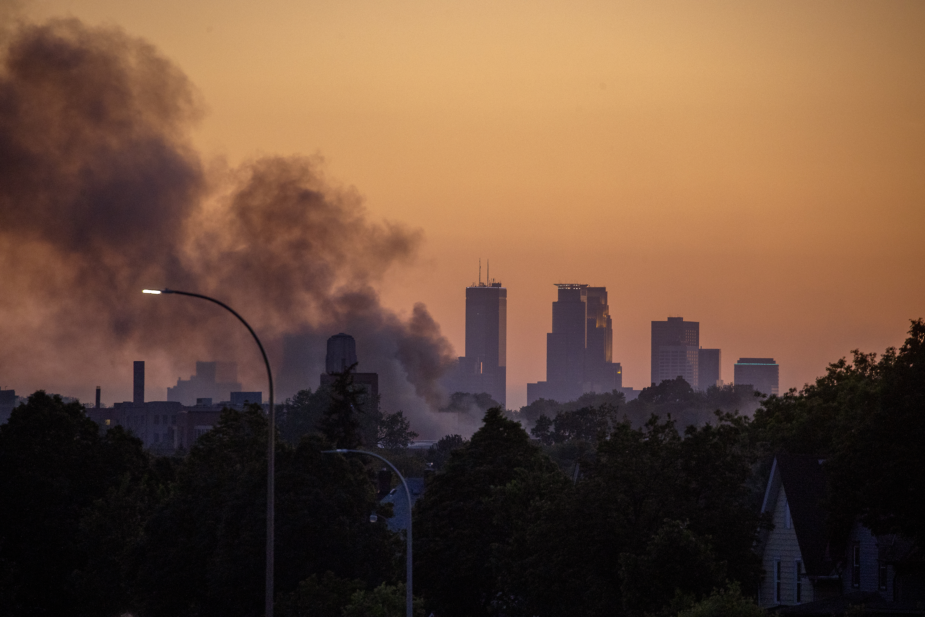 The sun set over the Twin Cities as smoke hovers over St. Paul, Minn., along University Avenue, on Thursday.