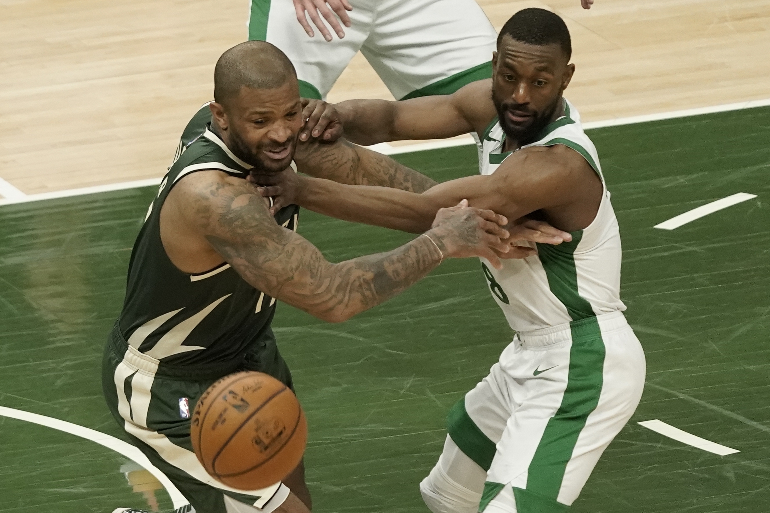 Milwaukee's P.J. Tucker and Kemba Walker go after a loose ball during the first half of Wednesday's contest.